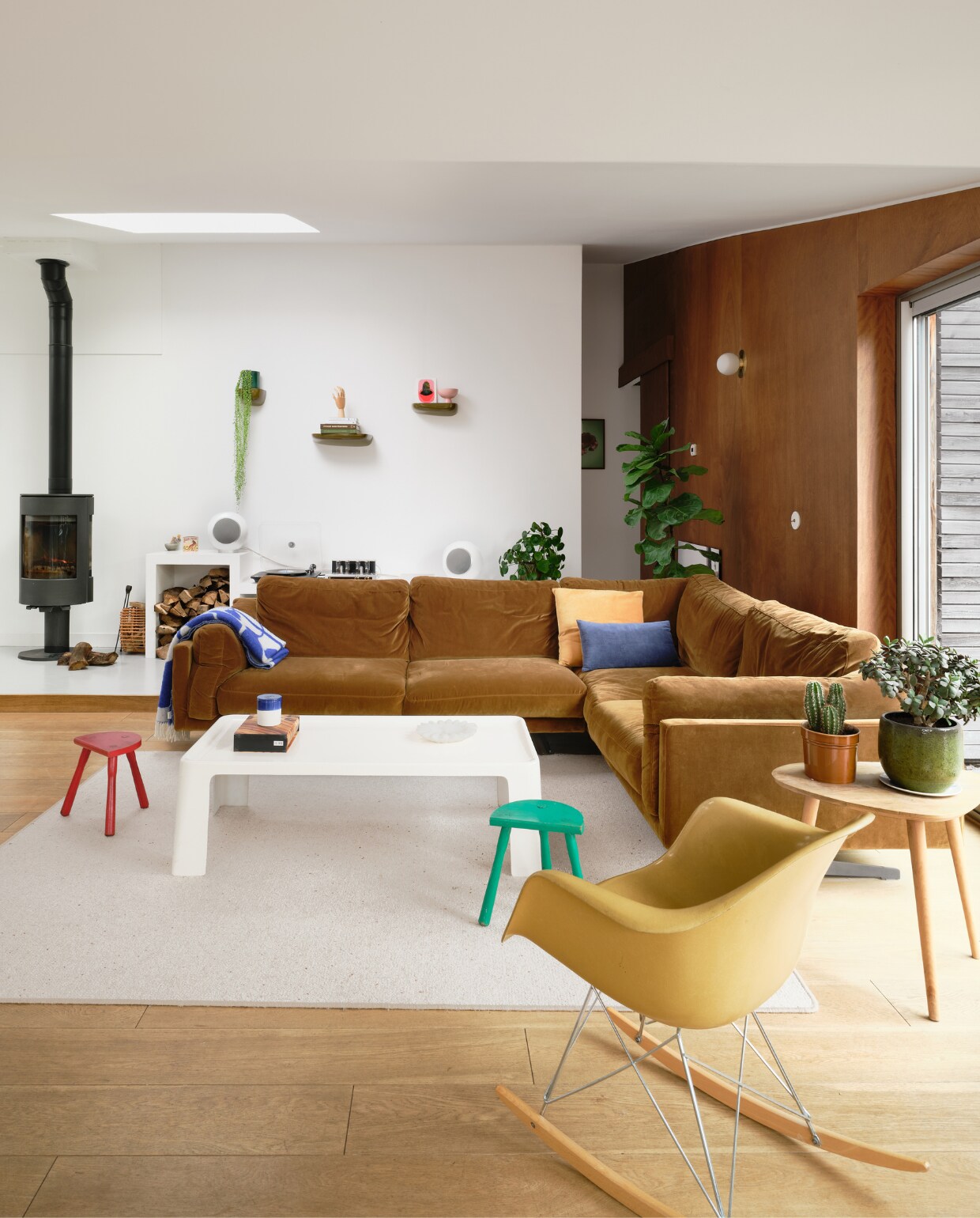 Bank AM.PM, schommelstoel Charles &amp; Ray Eames, witte vintage salontafel C&amp;B Italia. Houten bijzettafel, wandplanken en wandpanelen zelfgemaakt door Mathieu. Oranje kussen H&amp;M Home. Wandmeubel en wandplanken Ronan &amp; Erwan Bouroullec. Kunstwerk in de nis Marion WaïWaï, speakers Elipson. Overig onbekend. vtwonen binnenkijken special 131-2024 | productie Living Inside | fotografie Mr. Frank