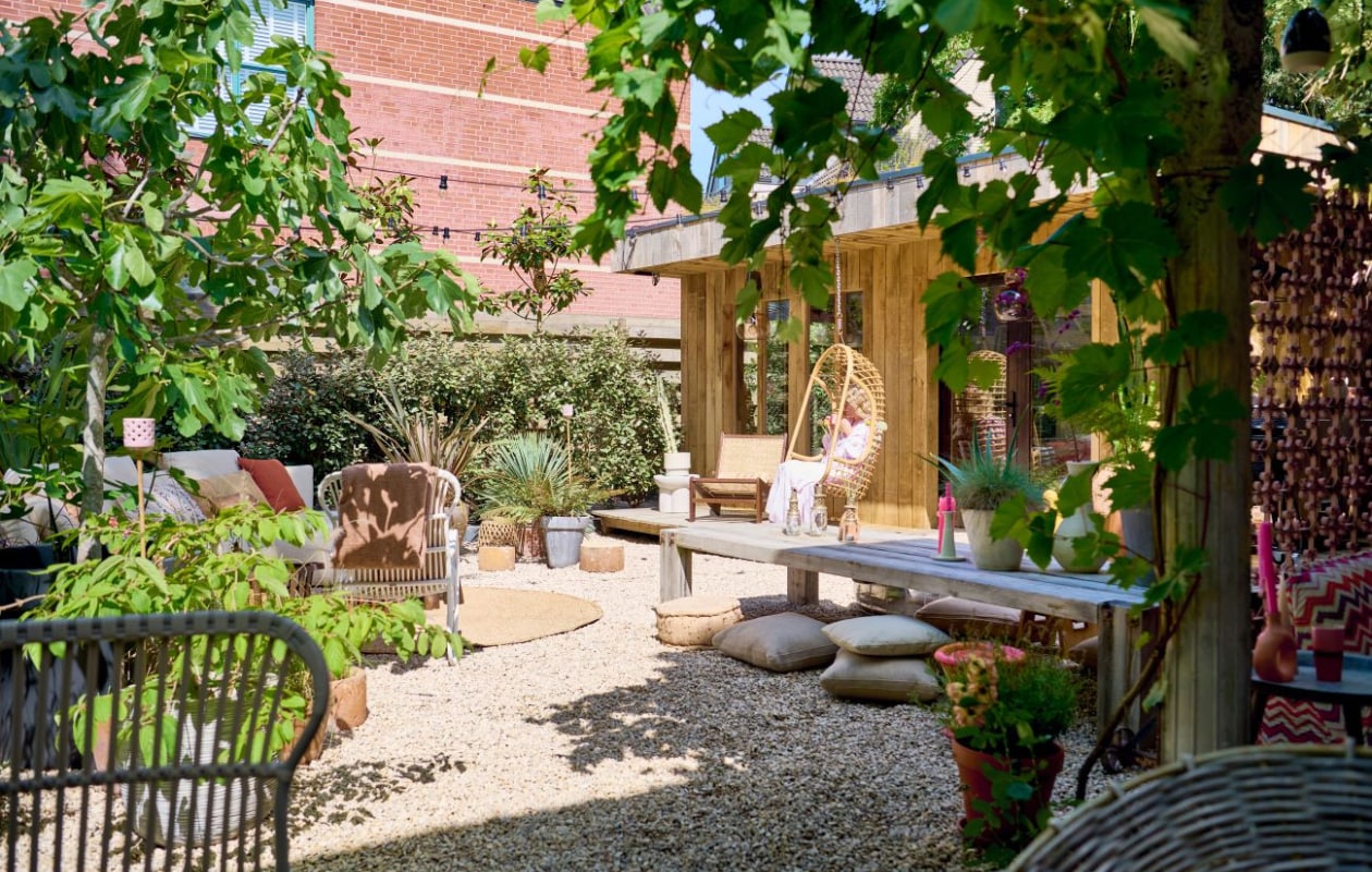 Tegen de schutting: groenblijvende haag van olijfwilgen, zwart siergras, magnolia’s op stam. In potten: Japanse sneeuwbal, vijg, Nieuw-Zeelands vlas, yucca rostrata, varen, cactus, helmgras, lavendel. Tegen de paal: druif en klimroos. Loungestoelen imaris-meubel.nl, hangstoel HKliving, bijzettafel Kwantum, lamp Fatboy. Overig zie andere fotobijschriften. vtwonen tuinspecial 10 | styling Liza wassenaar | fotografie Sjoerd Eickmans