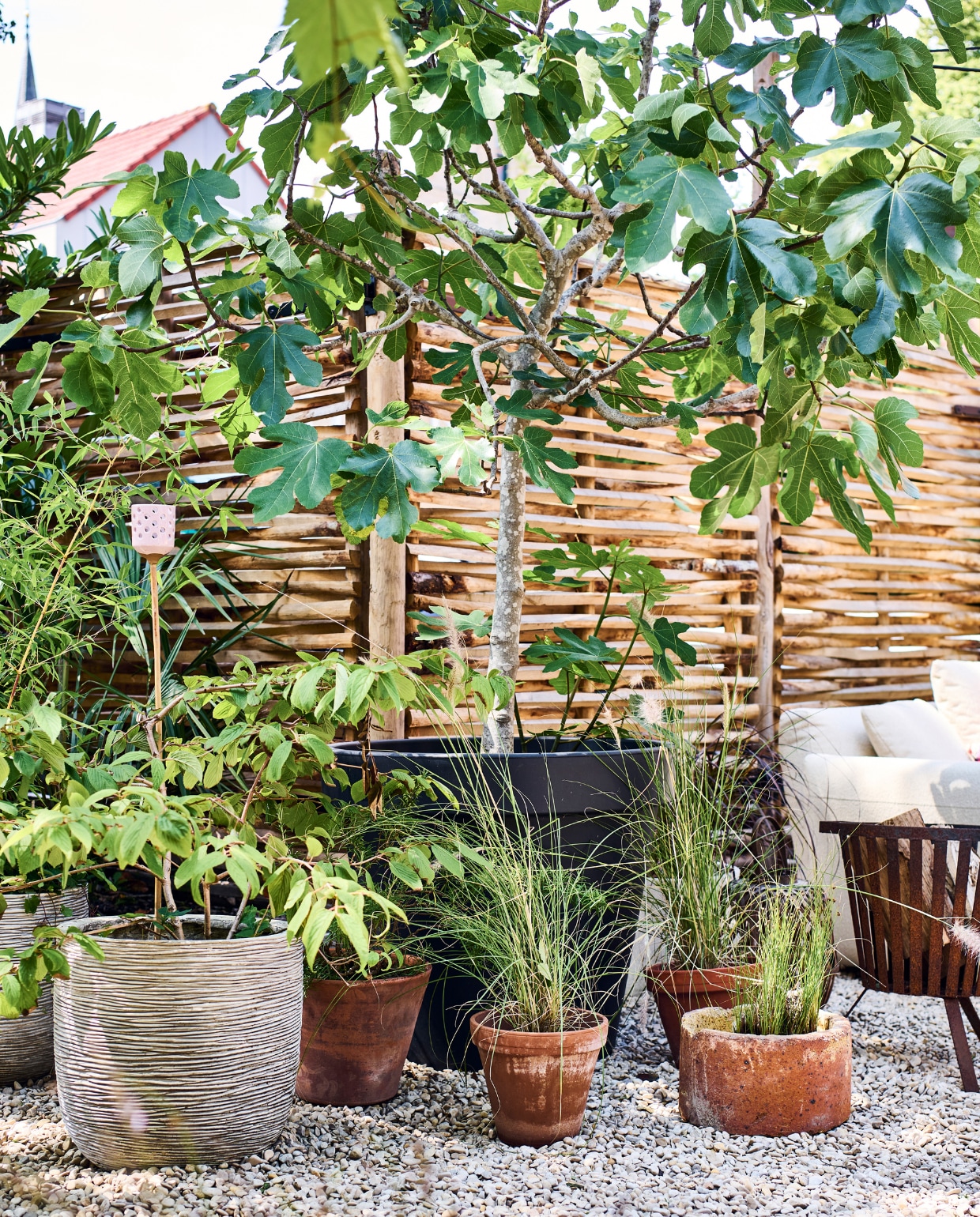 Potten van onder andere Intratuin, met Yucca rostrata, lampenpoetsersgras, varen en Nieuw Zeelands vlas. Bamboe buitenlamp Kwantum. vtwonen special tuin 10 | styling Liza wassenaar | fotografie Sjoerd Eickmans