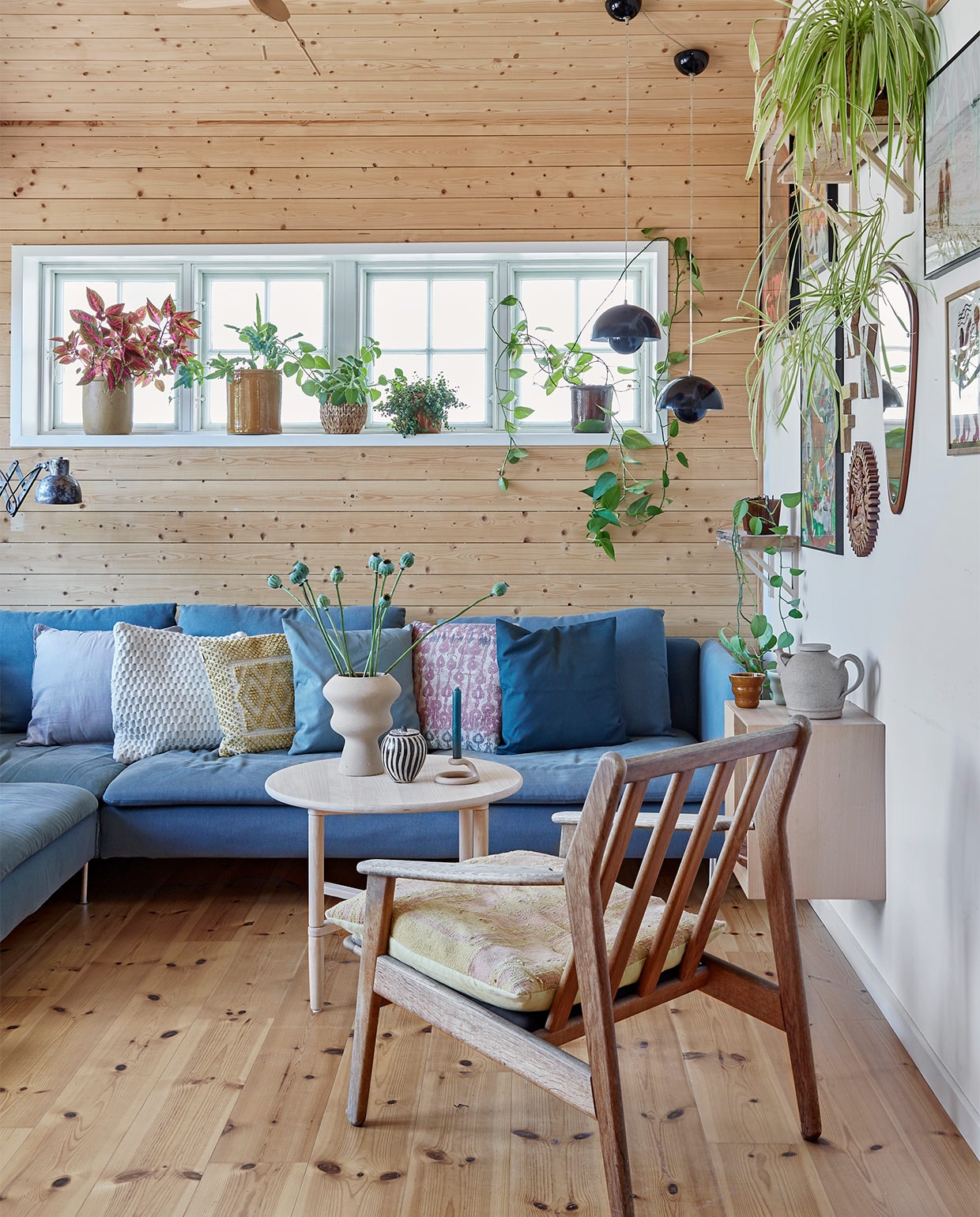 Blauwe bank Ikea. Kussens Au Maison en Madam Stoltz. Stoel en stoelkussen erfstukken. Ronde salontafel en hangend kastje DBA (Deense eBay). Beige vaas Ilva. Zwart-witte vaas, theepot en spiegel kringloop. Kandelaar Anthropologie. Wandlamp Leben CPH. Bloempotten voor het raam erfstukken en kringloopvondsten. Hanglampen Flowerpot &amp;Tradition. Aan de muur foto’s van reizen en kunst van een galerie in Ebeltoft. Wandplank zelfgemaakt. Overig onbekend. vtwonen special zomerhuizen 07-2021 | productie LIVING INSIDE | fotografie Anitta Behrendt | styling Rikke Graff Juel
