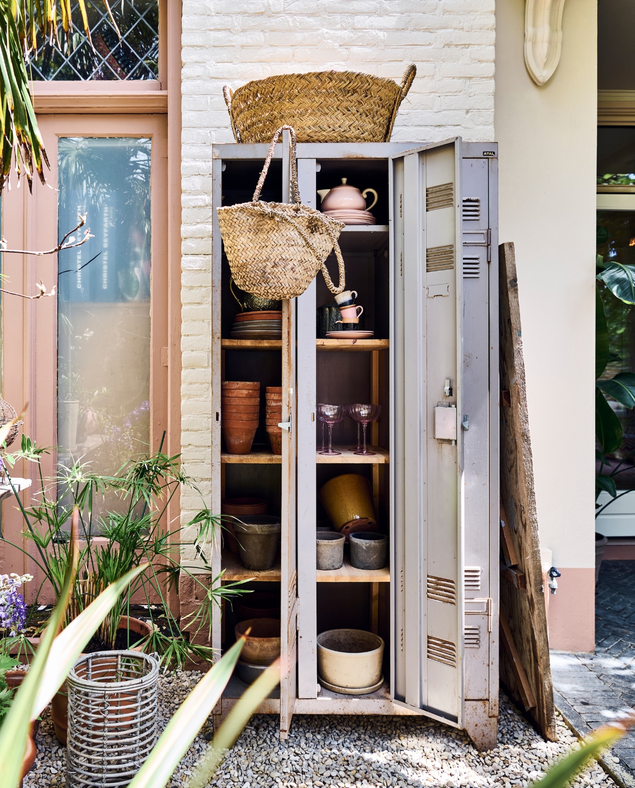 Papyrusplant. De vintage lockerkast stond in eerdere huizen binnen, nu als opberger buiten. Manden Household Hardware. Theepot en borden antiek. Koppen en schotels HKliving. Glazen Sissy-Boy, witte pot vtwonen. vtwonen special tuin 10 | styling Liza wassenaar | fotografie Sjoerd Eickmans