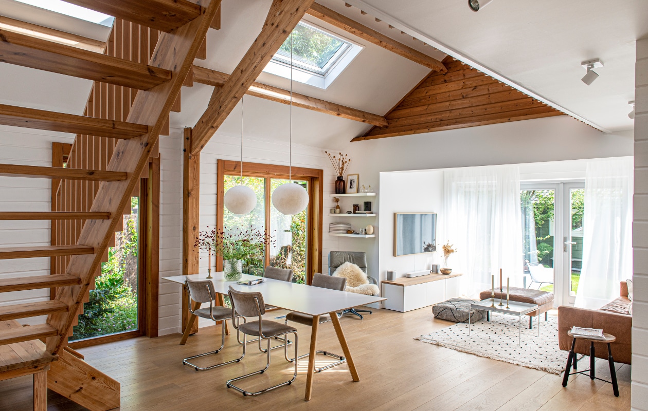 Eikenhouten vloer Dirkedaen, eettafel en salontafel Hay, stoelen Tubax, hanglampen LumaLano, Artifort-draaifauteuil van Jordy’s opa, vacht Ikea. Grote bruine vaas Cin in Wonen, tv Samsung, kast eronder Ikea met daarop een eikenhouten plank, geluidsinstallatie Sonos, messing schaal uit India, lage poef en kleed uit Marokko, hoge poef en bank Loods 5, kandelaars en driepotige tafel kringloopwinkel, spots Philips, gordijnen Hema. vtwonen 04-2023 | productie De Binnenkijkers | styling Jeske Weel | fotografie Caroline Coehorst