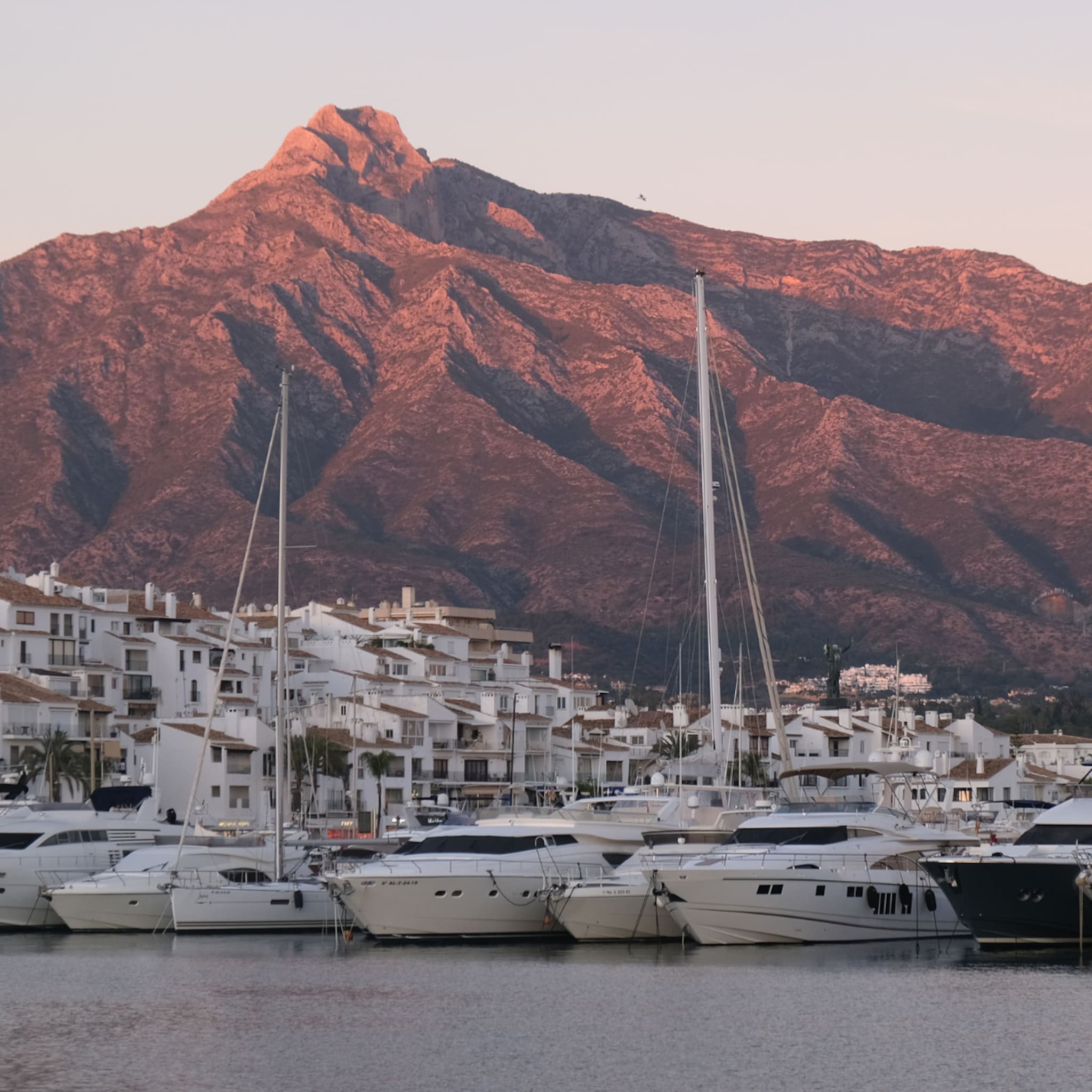 Haven in Marbella met boten en een grote berg