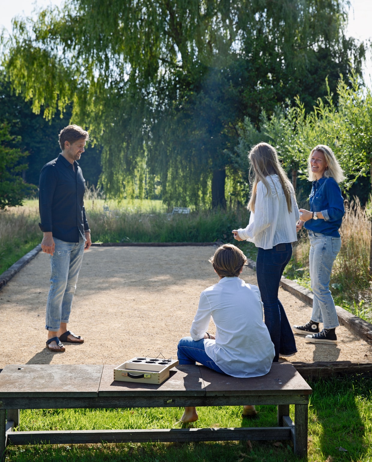 Bank gemaakt door tuinman, daarachter een grote wilg, jeu-de-boulesbaan gemaakt met oud hout van een buurman. vtwonen Tuin 10 | styling Ilona Jongepier | fotografie Dana van Leeuwen
