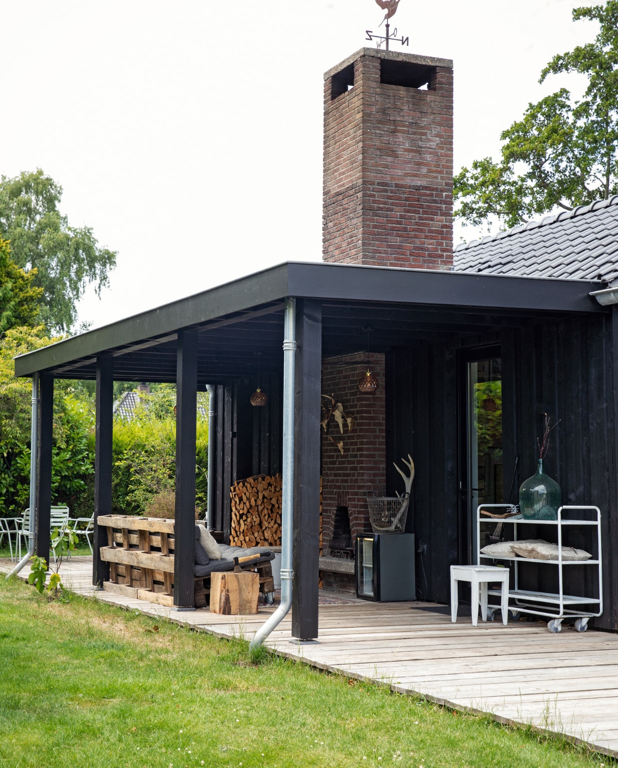 Trolley van HKliving en kruk uit kringloopwinkel, beide zelf wit geverfd, zitbanken gemaakt van oude pallets. &gt;&gt; In de potten staan planten die elders uit de tuin werden gehaald. vtwonen Tuin 10 | styling Ilona Jongepier | fotografie Dana van Leeuwen