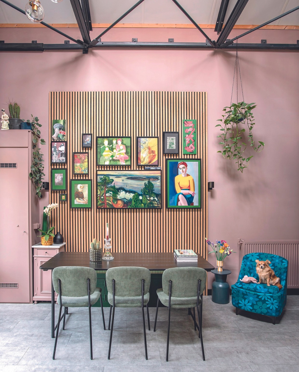 Zwarte eettafel Army van vtwonen, stoelen Job van Gamma, vintage fauteuil DroogVintage, bijzettafel gemaakt van bloempot Jysk, gestreepte bloempot Henny’s Home, bloemen Botanical Collection van Lego, nachtkastje vintage, kandelaar zelfgemaakt, eiken wandpanelen Karwei, wandspot Nymåne van Ikea. Gallery wall met de klok mee: etalagehoofd @chantal_paspop, kunstfoto Maudy Brussel, familieportret door @ellygommers_art, graffiti door zoon @nanneboere, vrouw Vilhelm Lundstrøm via Pstr Studio, televisie The Frame van Samsung, meisje kringloop, munt beschilderd door Cocky, papierkunst Ineke Tijsseling, illustratie van de vier kinderen door dochter @ocean_tattoo, midden: bloemposter Nin-Nit. Muurverf Sulking Room Pink van Farrow &amp; Ball. Overig kringloop of onbekend. vtwonen 05-2024 | fotografie Ton Bouwer