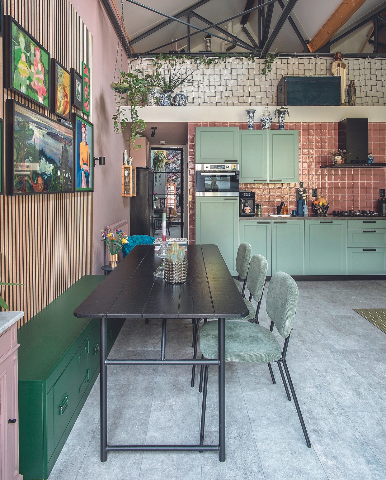 Eettafel Army en eettafelbank van vtwonen. Stoelen Job van Gamma, gestreepte bloempot Henny’s Home, bloemen Botanical Collection van Lego, nachtkastje vintage, kandelaar zelfgemaakt, wandpanelen Karwei, wandspot Nymåne van Ikea, flesvaas Foekje Fleur, houten bloem @cut.spul, fruitmand Pels Bloemisten, koffiemachine Philips, wandtegels Tegels in Huis, verf keuken Green Smoke van Farrow &amp; Ball, vloer betonlook laminaat van Carpetright. Kunstmuur: familieportret @ellygommers_art, graffiti door zoon @nanneboere, vrouw Vilhelm Lundstrøm via Pstr Studio, televisie The Frame van Samsung, bloemposter Nin-Nit. Overig kringloop of onbekend. vtwonen 05-2024 | fotografie Ton Bouwer