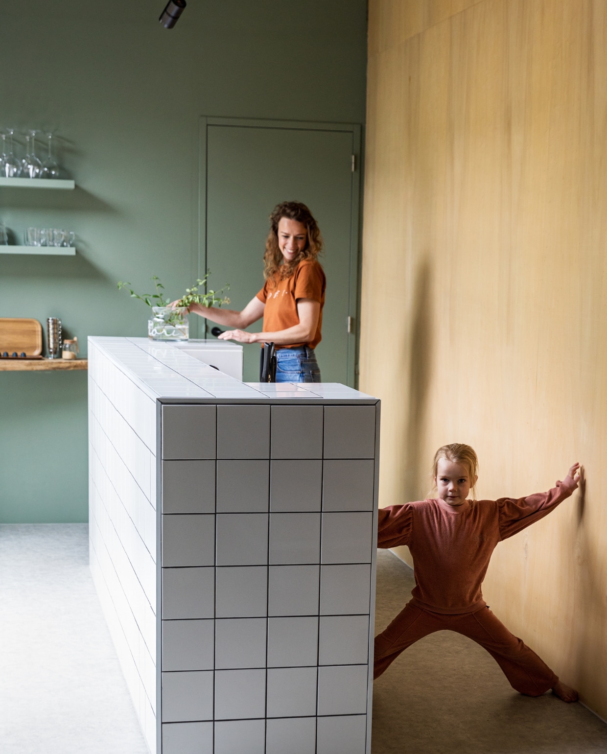 Keukenblok eigen ontwerp maatwerk, afgewerkt met geglazuurde tegels Praxis. Houten wand Okoume platen Bouwcentrum Driessen. Houten schappen koffiebar resthout meubelfabriek, deels geverfd in kleur Geordend van Histor. vtwonen 01-2022 | styling Ilona Jongepier | fotografie Dana van Leeuwen | visagie Djolien de Kreij