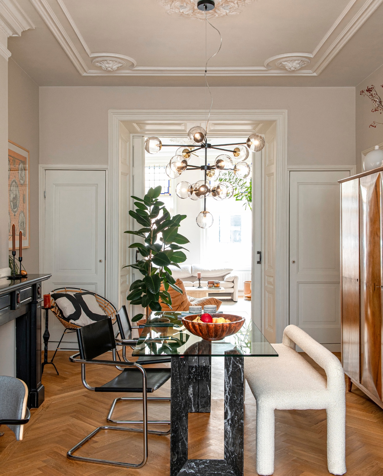 Kledingkast, tafel van Cattelan Italia en stoelen Marktplaats. Bank en hanglamp Made. Fruitschaal kringloopwinkel. Deuren inbouwkasten Mammoet Oude Bouwmaterialen. Verzameling witte vazen Marktplaats en kringloopwinkel. Bollamp Ikea. Overig onbekend. vtwonen 05-2024 | productie De Binnenkijkers | styling Jeske Weel | fotografie Caroline Coehorst