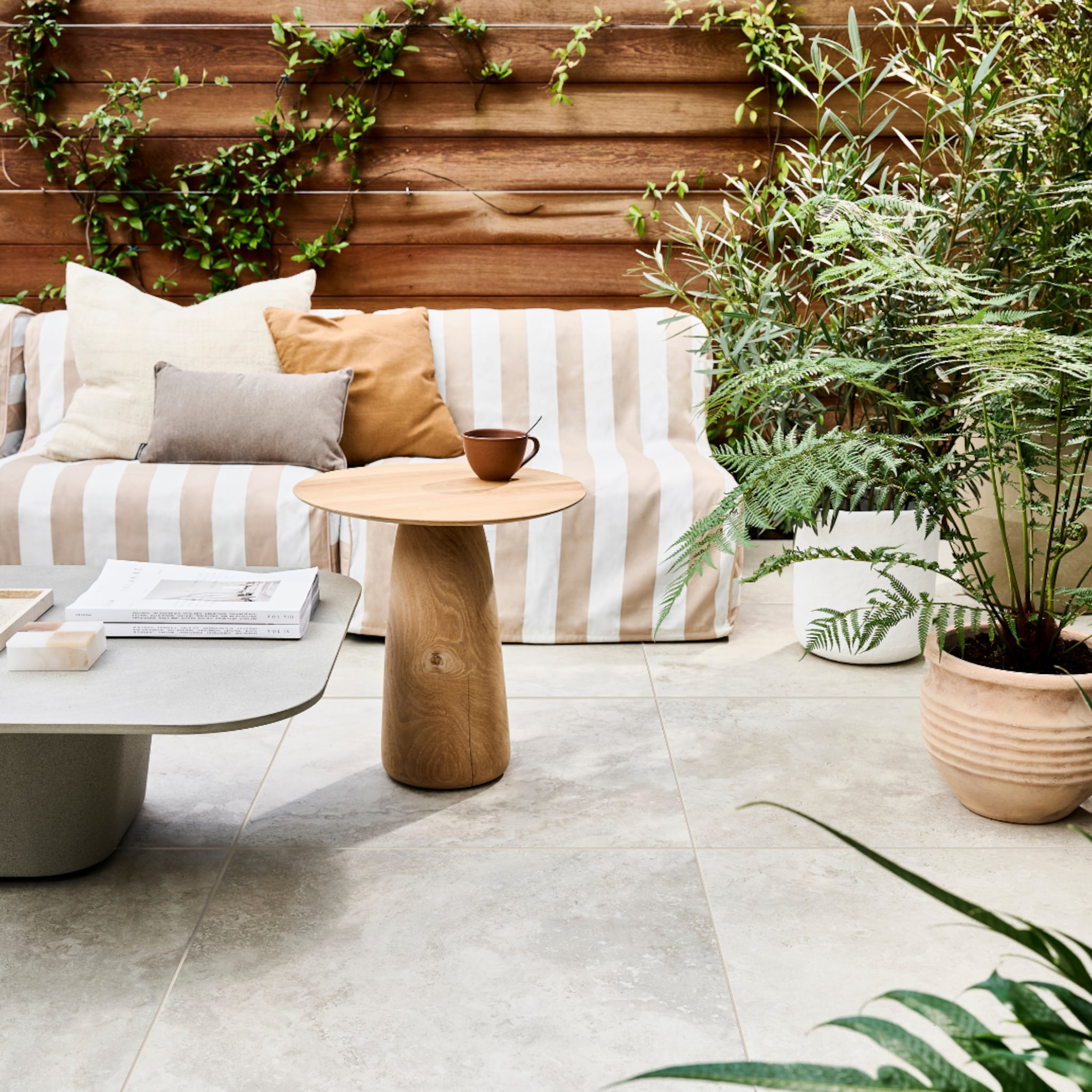 Terras met tuintegels en een bruin gestreepte loungeset
