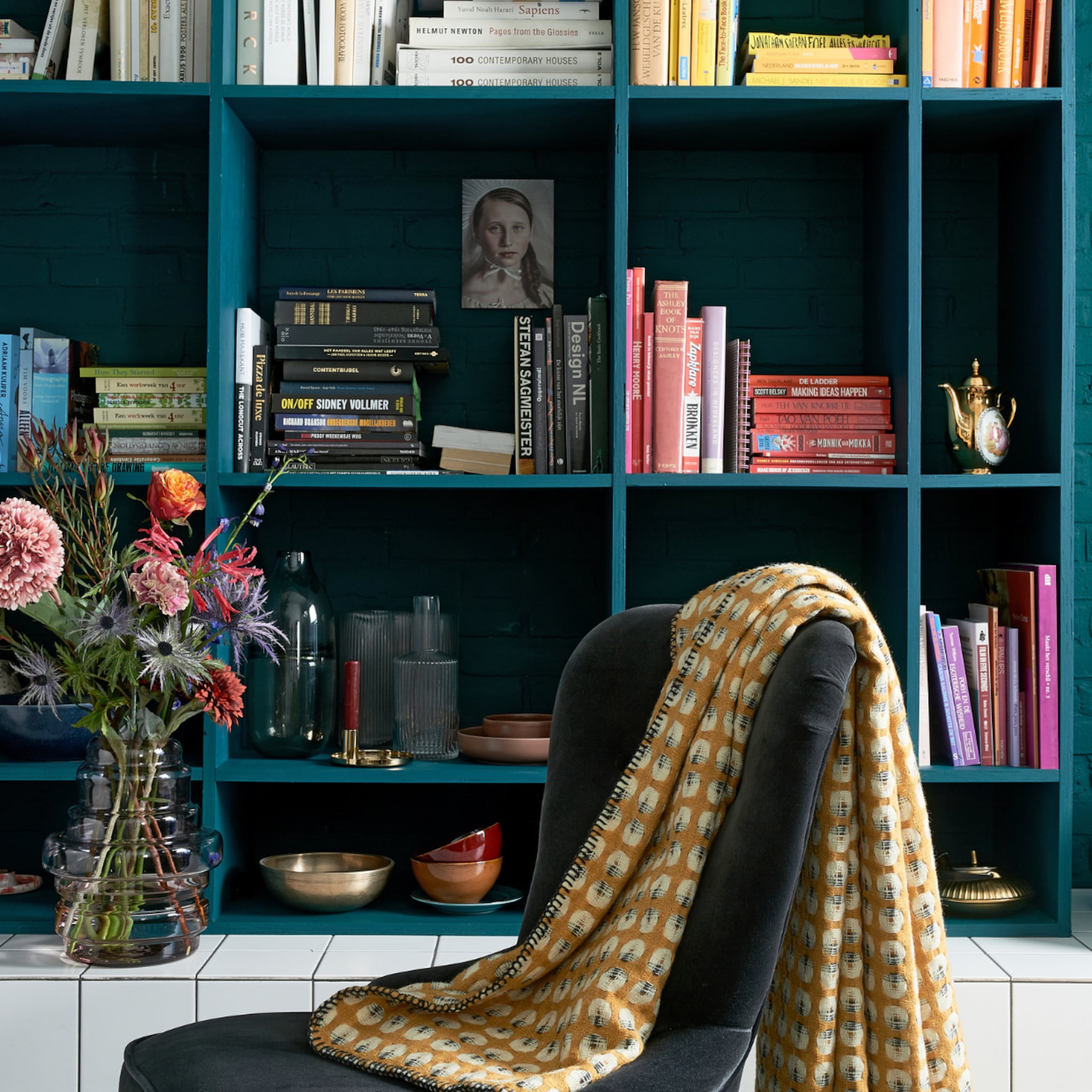Blauwe vakkenkast met boeken en woonaccessoires