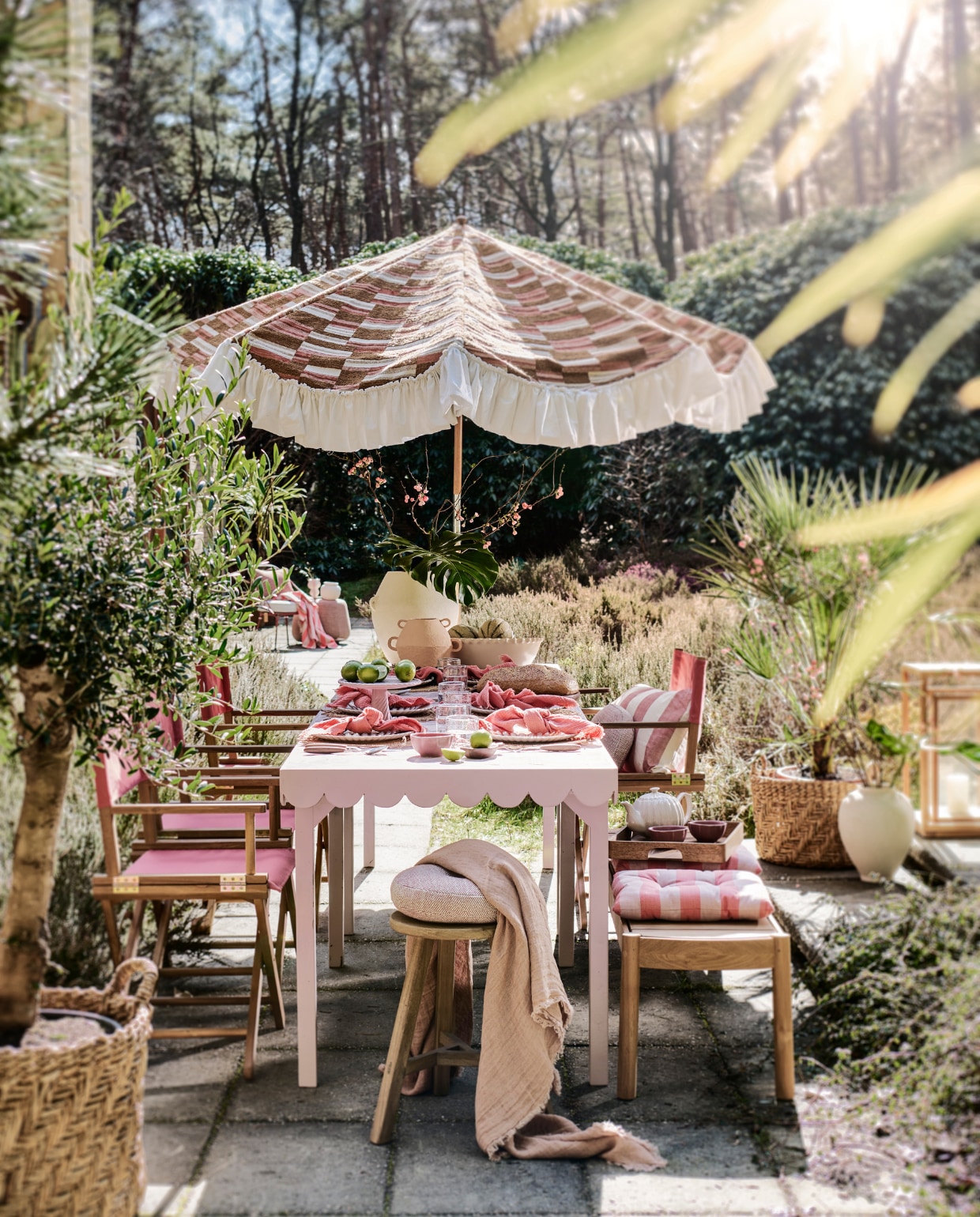 Tweedehands parasol prijs op aanvraag (com-anders.nl), met nieuwe stof Missori LR-347-21 van Elitis prijs op aanvraag (loggerewilpower.com). Tafel op maat gemaakt, prijs op aanvraag (com-anders.nl), met roze tegels Zellige Gris Rose Poisson Echelles, 10x10 cm, per m² € 179,50 (designtegels.nl). Houten kruk € 69,99, rieten placemats, per stuk € 9,99, glazen borden, per stuk € 6,99, kleine witte vaas € 39,99, manden per stuk € 89,99, witte vaas op de grond € 69,99, gestreepte kussens, per stuk € 17,99 (zarahome.com). Duurzaam teakhouten lantaarn € 499,-, duurzaam teakhouten bank € 2000,-, roze poef € 1110,-, parasolvoet € 109,-, ronde kussens 30 cm (Ø) € 150,-, (dacks.nl). Terra stalen stoel € 525,- (extravert.nl). Waterglazen, per stuk € 7,99, roze servetten, set van 2 € 12,99, onderste borden, per stuk € 9,99, roze schaaltjes, per stuk € 4,99, theepot € 29,99, houten dienblad € 39,99, roze doek op stoel op achtergrond € 22,99, roze-wit gestreepte vaas links op achtergrond € 19,99 (hm.com). Bestek Ottolenghi Feast van Serax, 24-delig € 137,-, stoelen Dalisa van Kave Home, duurzaam acaciahout en polyester, 55x43x88 cm (bxdxh), per stuk € 106,- (vtwonen.nl/shop). Planten prijs op aanvraag (plantje.nl). Grote schaal € 59,99, lichtroze plateau € 39,99 (sissy-boy.com). Roze plaid op voorgrond van Maison de Vacances € 210,-, houten dienblad van Serax € 99,- (couleurlocale.eu). Houten bakje vooraan op tafel € 12,95, witte vaas met oren Sava € 169,- (urbannatureculture.com). vtwonen 06-2023 | styling Liza Wassenaar | fotografie Sjoerd Eickmans