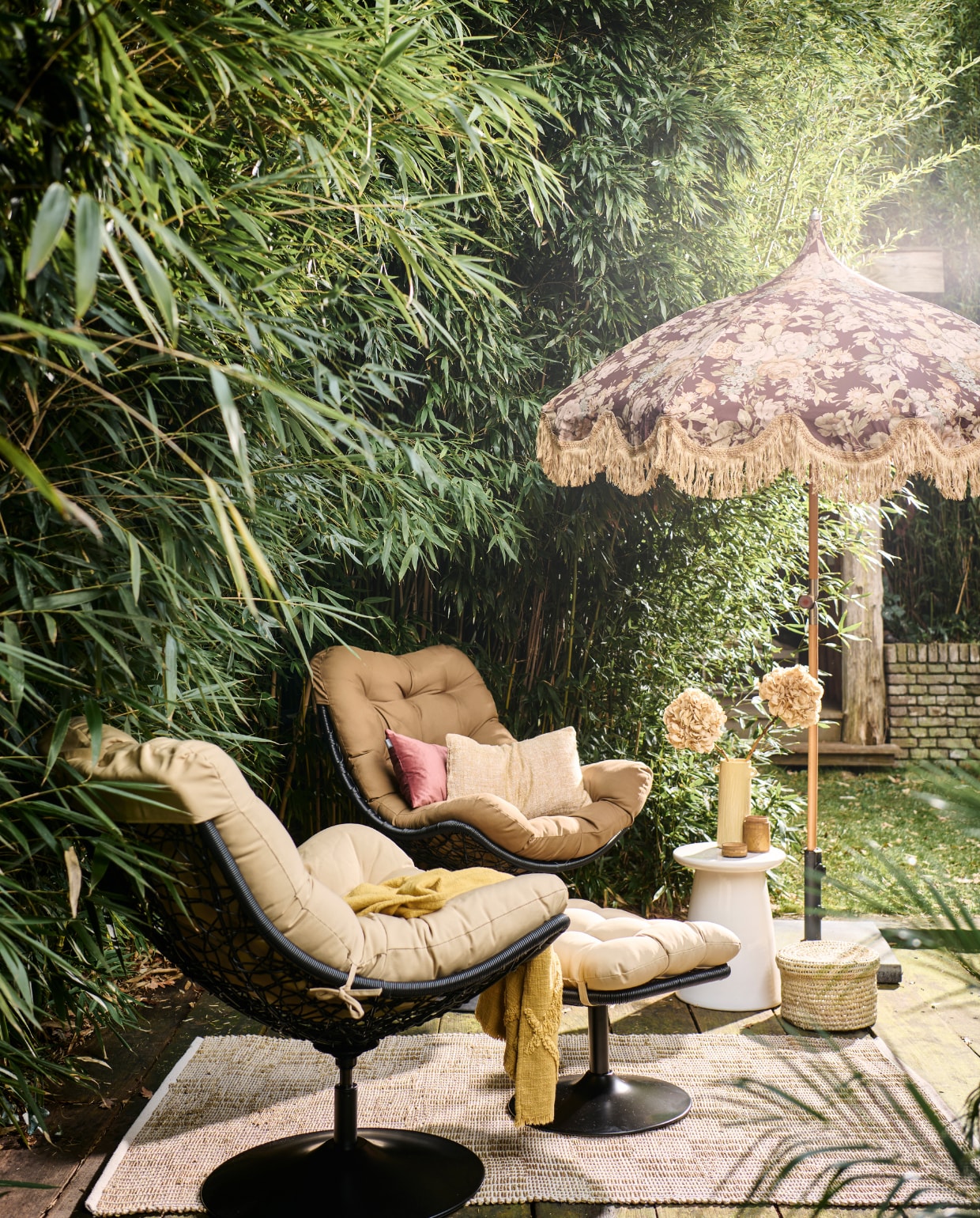Rotan draaifauteuil Vive van Woood, met zitkussen, 82x105x100 cm (bxdxh) € 299,-, witte keramieken bijzettafel Button van vtwonen, 35x45 cm (Øxh) € 129,- (vtwonen.nl/shop). Rotan hocker Vive van Woood € 149,- (basiclabel.nl). Stoffen parasol uit collectie van Marie Olsson Nylander € 395,- (hkliving.com). Rieten mand, prijs op aanvraag (com-anders.nl). Gele keramieken vaas € 54,95, geel geweven kussen, 30x50 cm € 59,95, gele geweven plaid € 59,95 (urbannatureculture.com). Roze fluwelen kussen, 30x50 cm € 39,95 (hetkabinet.nl). Houten pot met deksel € 12,50 (jolandelijk.nl). Geweven vloerkleed van Madam Stoltz, 120x180 cm € 58,24 (deens.nl). Overig privébezit. vtwonen 05-2023 | styling Marlies Does | fotografie Sjoerd Eickmans