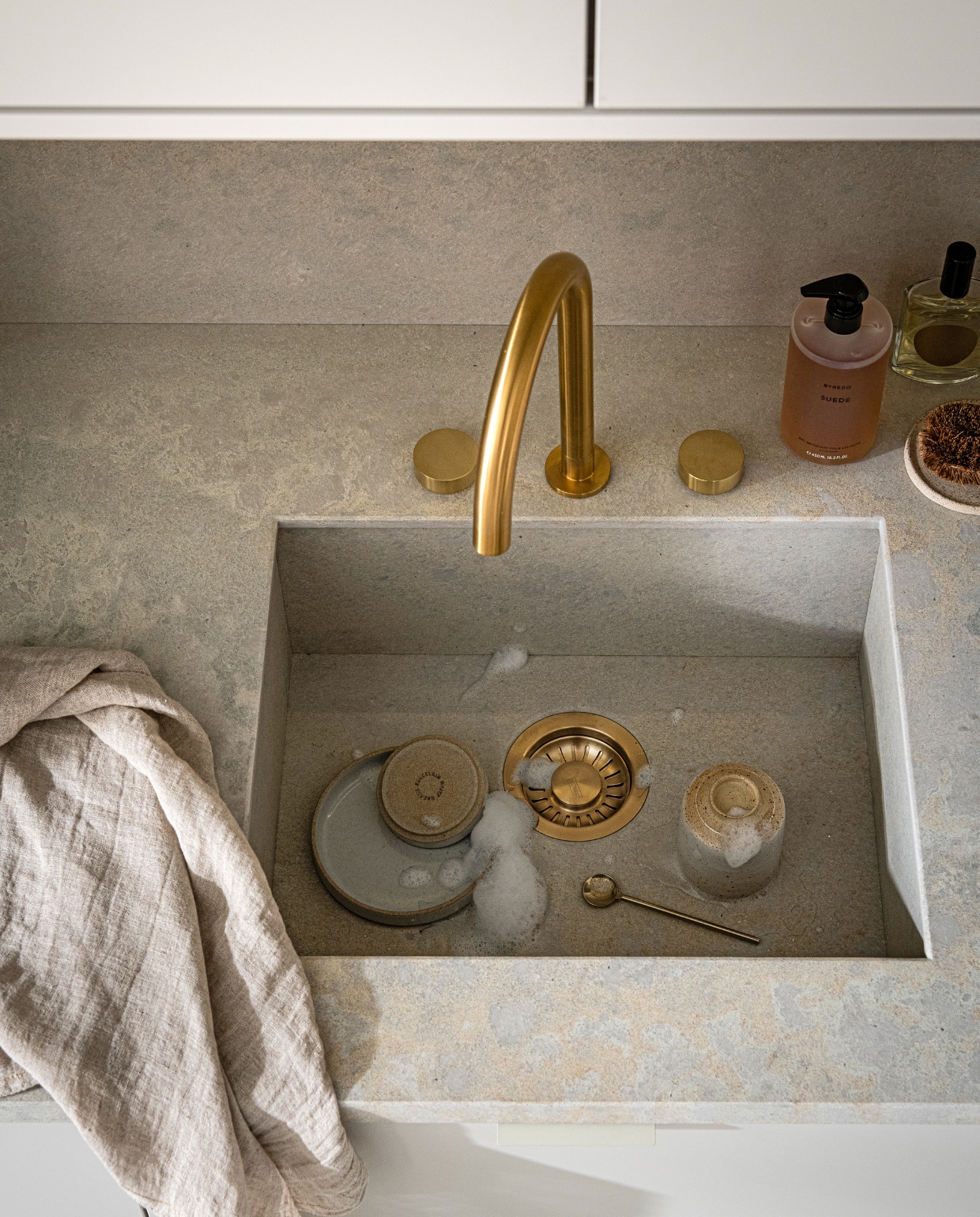 vtwonen collectie (Keuken Basic Greige, zoals getoond: € 21.500,-). M.m.v. kikubari.nl (spray van Lingua Planta), vtwonen.nl (theedoek uit de vtwonen collectie), skins.nl (handzeep Suede Byredo), thefinestore.com (servies). Overig privébezit. vtwonen 03-2021 | productie Tanja Saarberg | styling Kim van Rossenberg | fotografie Sjoerd Eickmans