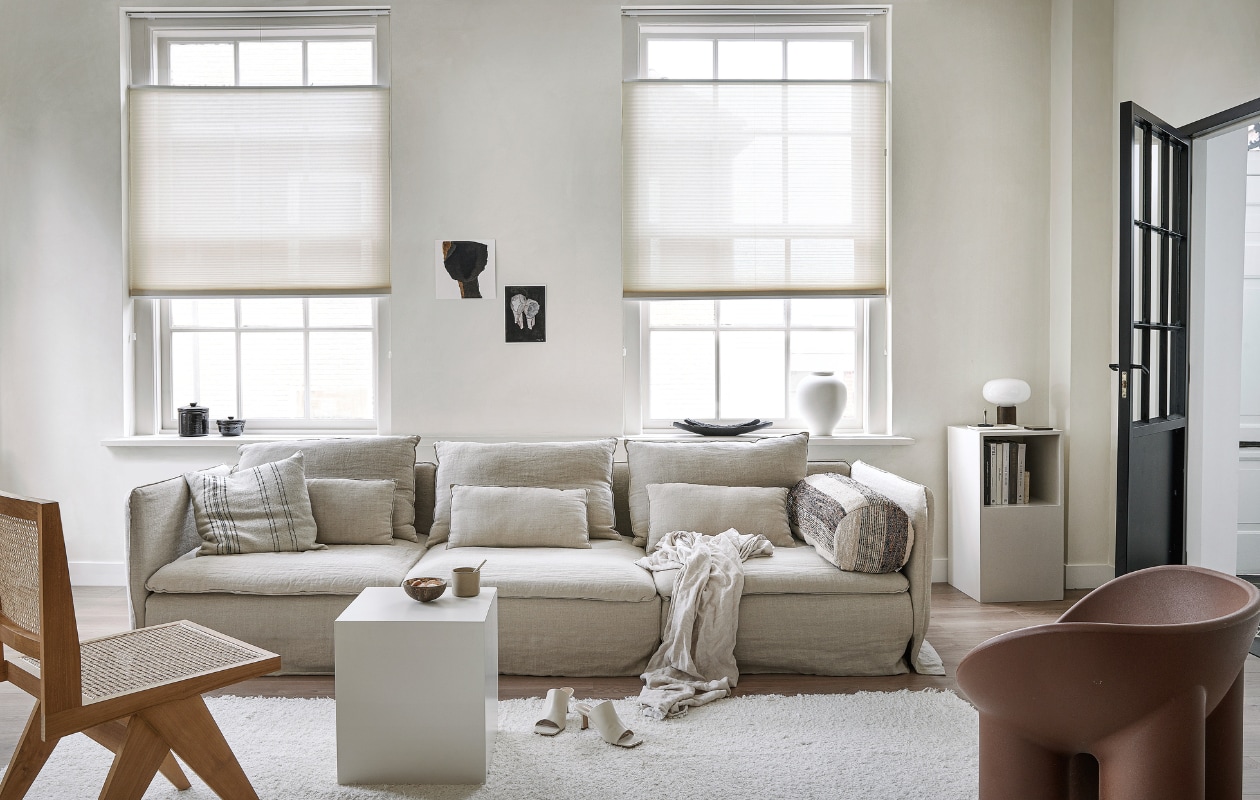 Lichtdoorlatend plisségordijn in kleur Linnenbeige (18074) vanaf € 204,39.m.m.v. karwei.nl (vtwonen EVC vloer in kleur Oat), ikea.nl (bank Söderhamn), bemz.com (linnen bankhoes), zarahome.com (linnen plaid, zwarte schalen, witte vaas), stories.com (schoenen), aimetestudio.com (houten stoel Pierre), puurdesign.nu (bruine stoel Roly Poly van Driade), casagitane.com (rond kussen Tronc), newworks.dk (tafellamp), bauwerkcolour.com (muurverf in kleur Mykonos). Overig privébezit. vtwonen 09-2021 | productie Tanja Saarberg | styling kim van Rossenberg | fotografie Peggy Janssen