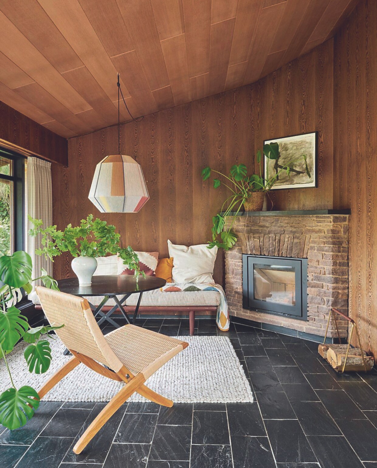 Loungebank erfstuk, plaid Fabelab. Kussens Ikea en H&amp;M Home. Lamp en vloerkleed Hay. Tafel Santa &amp; Cole, vaas Studio Arhoj, loungestoel Morten Gøttler, leisteentegels origineel. vtwonen 06-2024 | fotografie Christina Kayser Onsgaard | styling Rikke Graff Juel