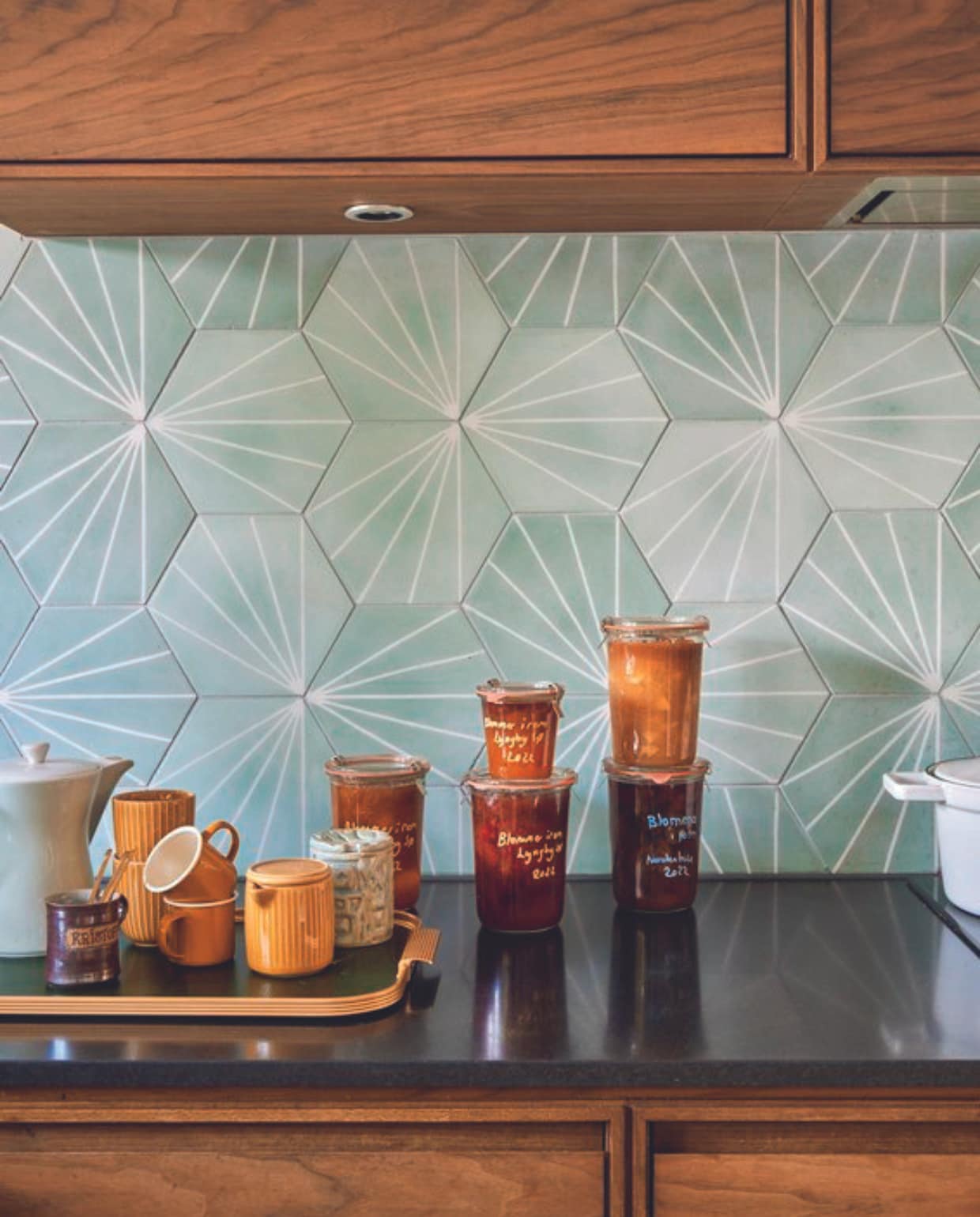 Keuken Koch, wandtegels MarrakechDesign, dienblad Kaymet, bruine geëmailleerde kopjes Fabelab, overige kopjes Flying Tiger, groene jampot Gitte Svarre Jensen, theepot erfstuk. vtwonen 06-2024 |styling Rikke Graff Juel | fotografie Christina Kayser Onsgaard
