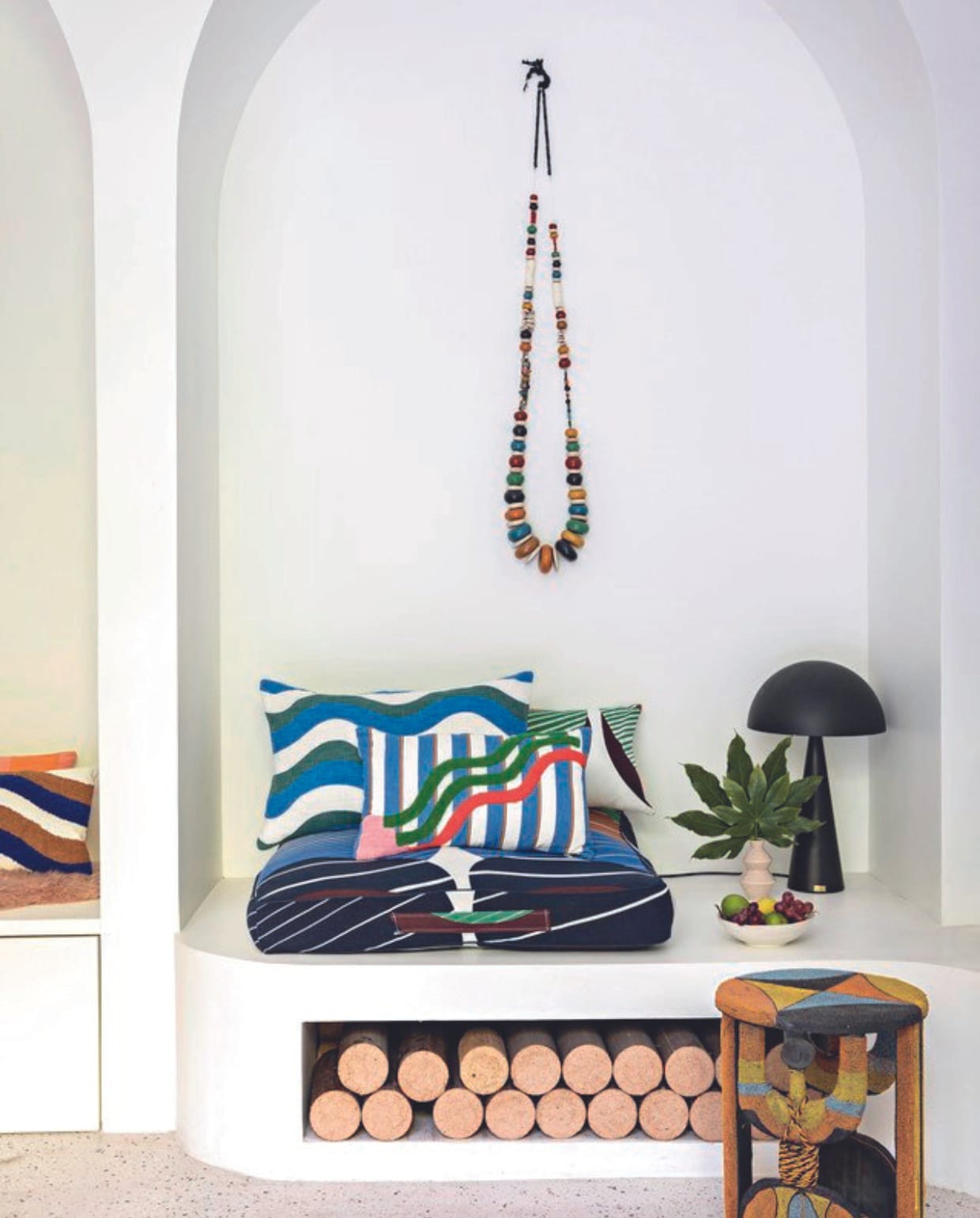 Kussens Ma Poésie, ketting Marokkaans souvenir, tafel Afrikaans souvenir, lamp Hübsch. vtwonen 06-2024 | styling Marie-Maud Levron | fotografie Yann Deret