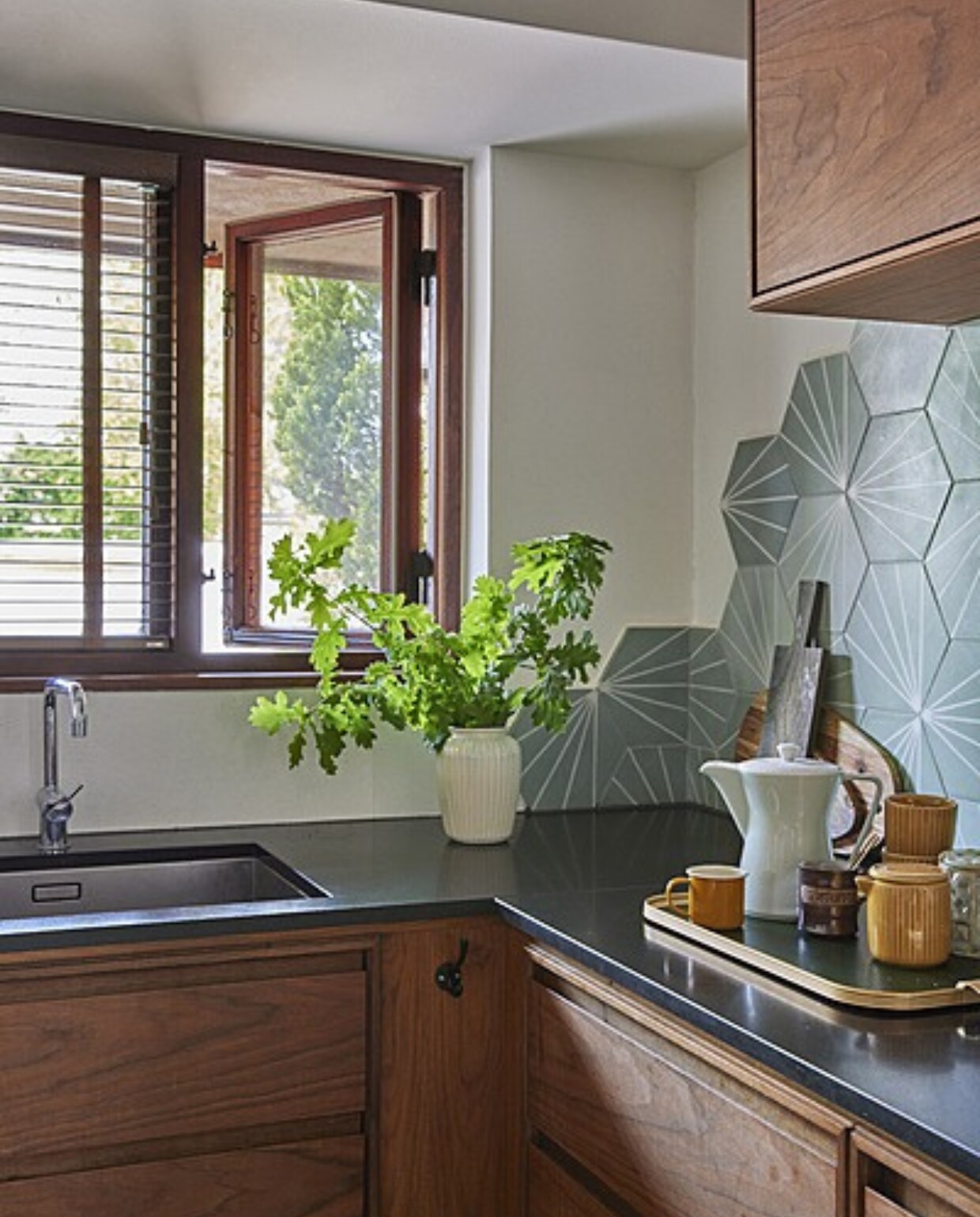 Keuken Koch, wandtegels MarrakechDesign, dienblad Kaymet, bruine geëmailleerde kopjes Fabelab, overige kopjes Flying Tiger, groene jampot Gitte Svarre Jensen, theepot erfstuk. vtwonen 06-2024 |styling Rikke Graff Juel |  fotografie Christina Kayser Onsgaard