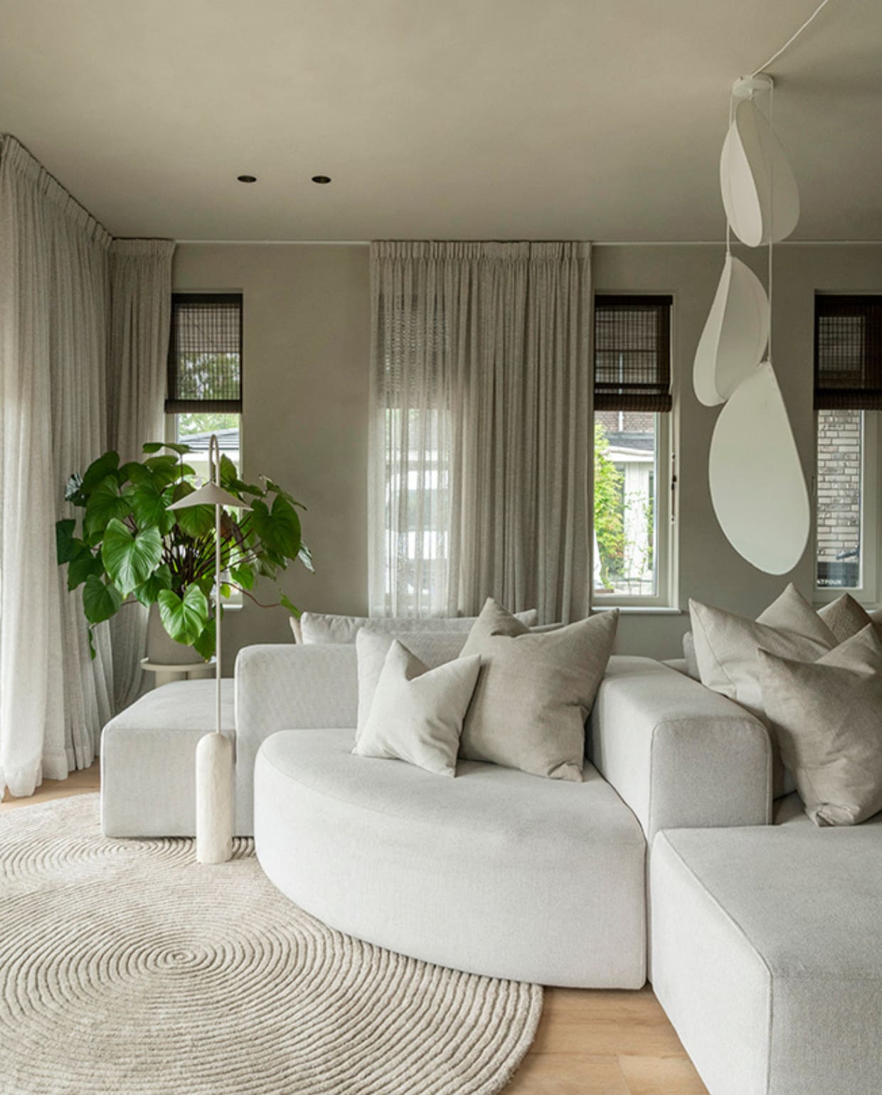 De woonkamer in de uitbouw heeft ramen aan drie kanten. De lampionnenlampen komen van Bolia. De modulaire eilandbank heeft zowel ronde als geometrische elementen en is van 4x6 Sofa. fotografie Muk van Lil