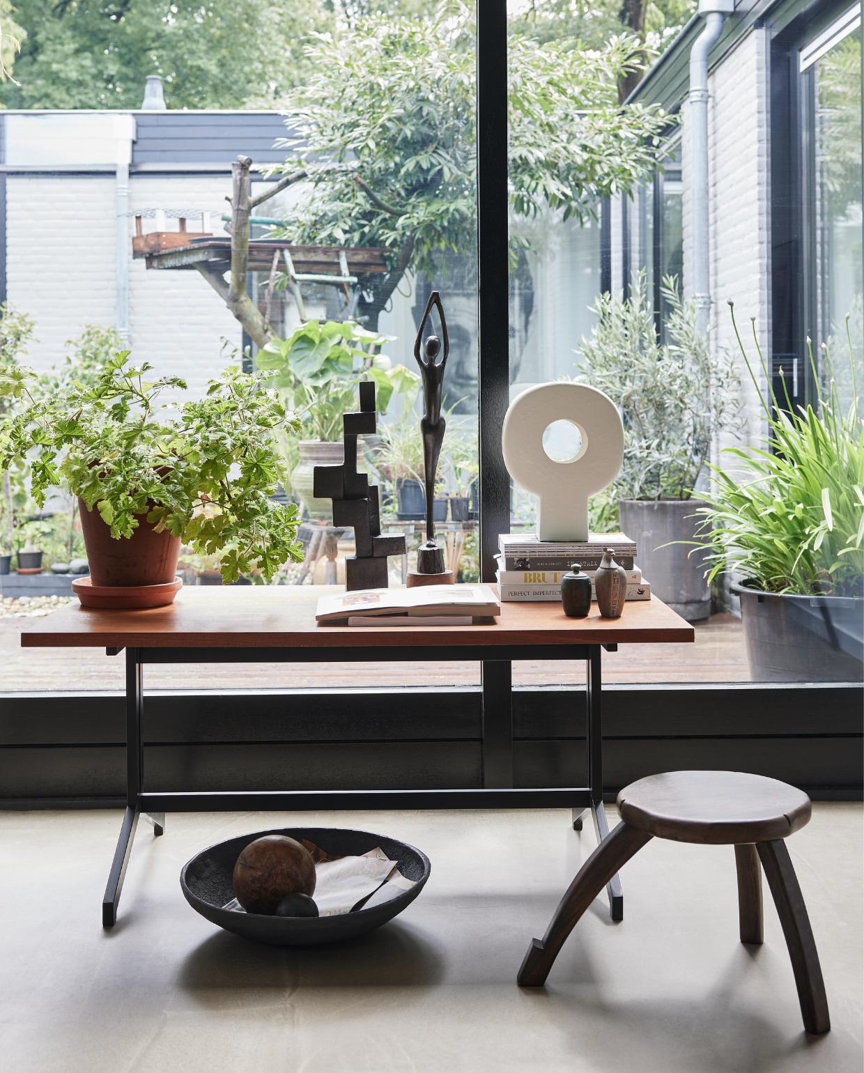 Vintage salontafel Eeka van Friso Kramer en Coen de Vries, 120x65x53,5 cm (lxbxh) € 175,- (neeflouis.nl). Keramische tafellamp Tree € 99,95, zwart metalen object Aosta € 119,-, stenen schaal Ateljé € 22,95, mangohouten plantentafel, 50x28 cm (Øxh) € 159,- (urbannatureculture.com). Beeld, souvenirs, houten bal en overig privébezit. vtwonen 10-2023 | styling Fietje Bruijn | fotografie Alexander van Berge