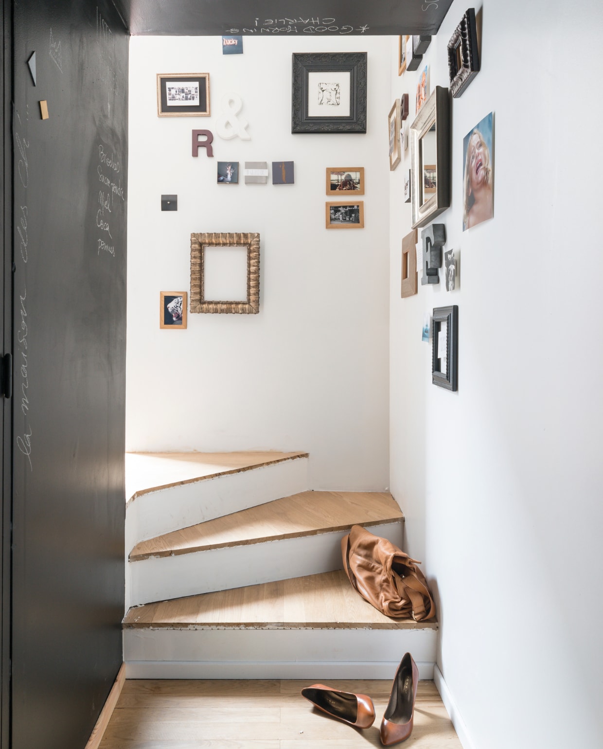 Het trapje leidt naar de entree, langs een wand vol familiefoto’s, tekeningen en sierobjecten. Houten dienblad van Habitat, keukenmachine van Kitchen Aid. Bron: vtwonen 03-2015 | fotografie Julien Fernandez, amandinejules.com | tekst Amandine Berthon | tekstbewerking Monique van der Pauw