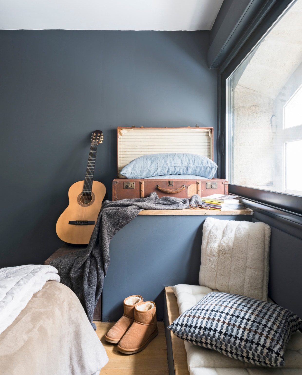 Een oude koffer uit de familie herbergt extra kussens. Het lage bankje is speciaal getimmerd als rustige gitaar-speel-plek. Het geblokte kussen is van www.madurahome.com Bron: vtwonen 03-2015 | fotografie Julien Fernandez, amandinejules.com | tekst Amandine Berthon | tekstbewerking Monique van der Pauw