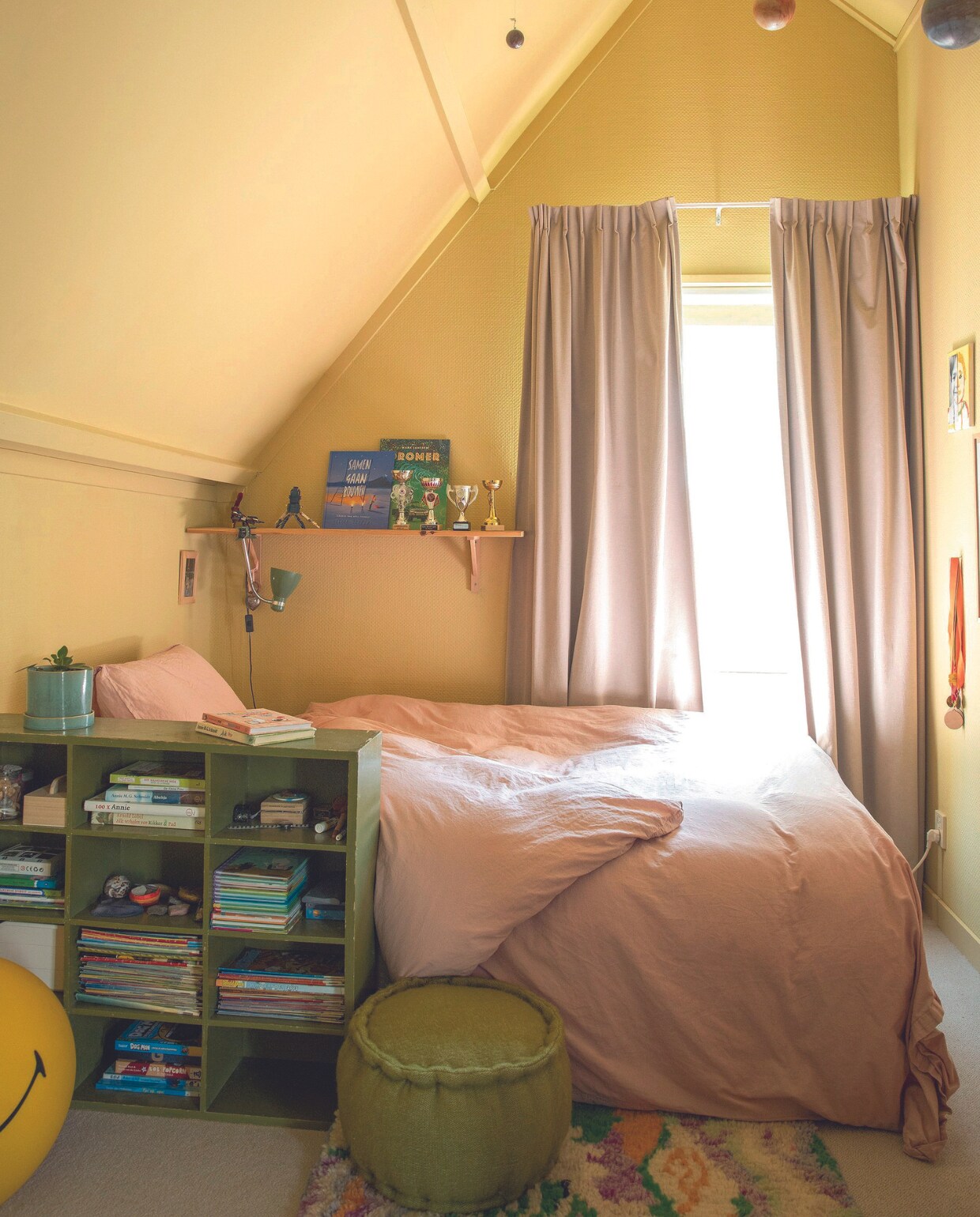 Beddengoed H&amp;M Home. Vloerkleed en poef Maison Aimélie. Vakkenkast Marktplaats, gordijnen Hema, wandplank Karwei, mobiel zonnestelsel Lidor, smiley Anna + Nina, muurkleur Sunlight van Little Greene. vtwonen 07-2024 | styling Ilona Jongepier | fotografie Dana van Leeuwen