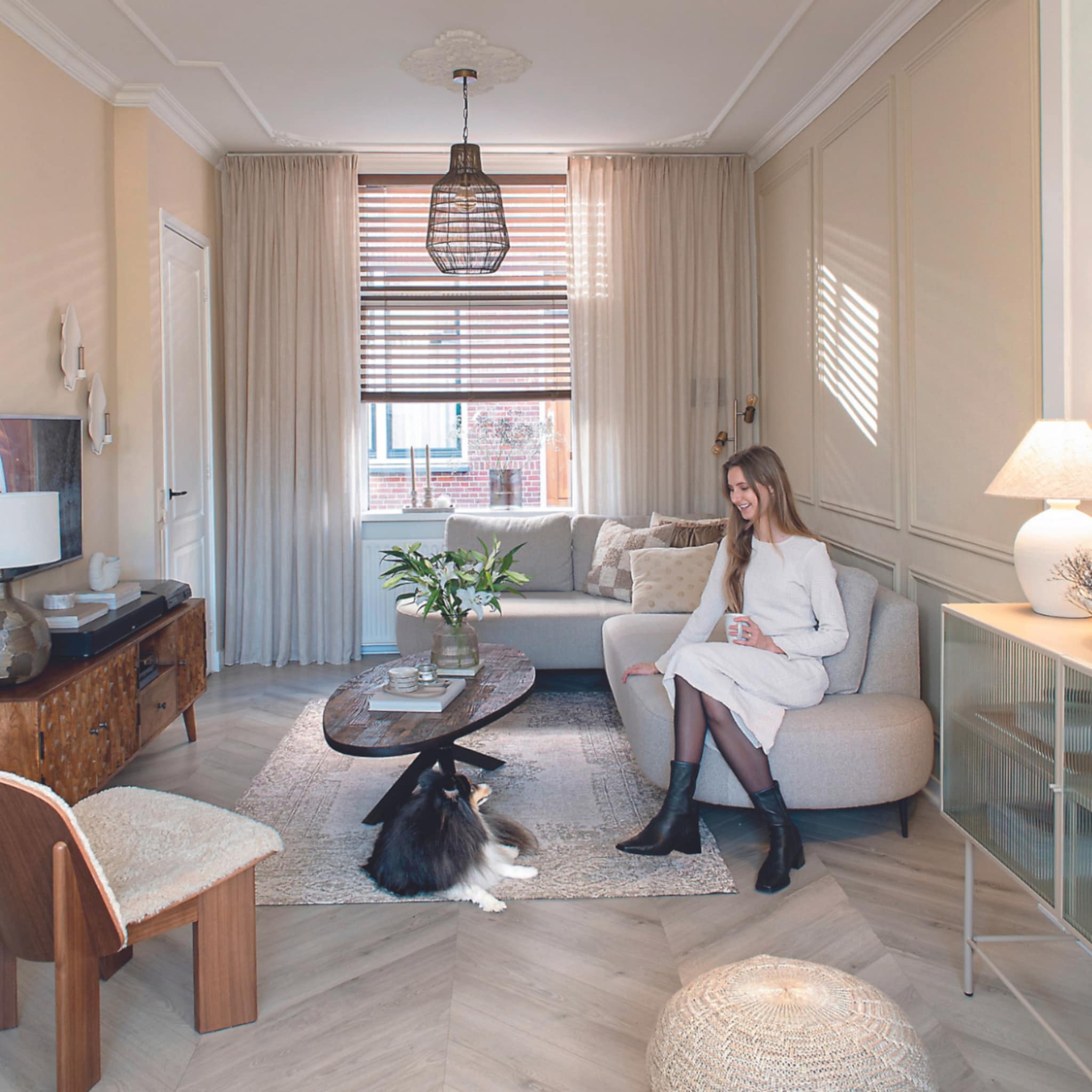 Beige woonkamer met een grijze bank en houten tv-meubel