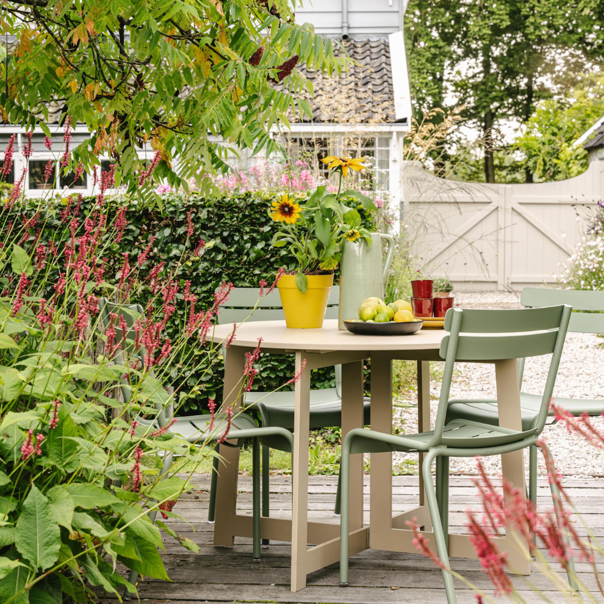 Tuintafel buiten met groene tuinstoelen