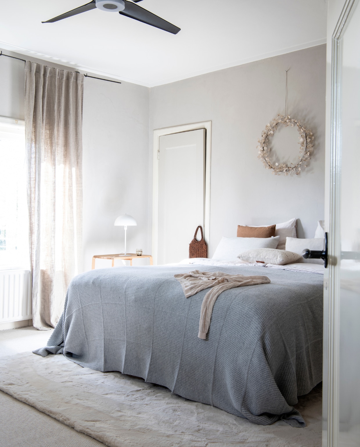 Kleur op muur RAL 7044, kleur op deur onbekend. Kandelaar K’willeminhuis. Vloerkleed Naduvi. Bed Ikea. Sprei Scapa Home. Dekbedovertrek Yumeko. Spiegel Vandaag van Concept Store Hengelo. Lamp Trapeze gold-white van Anne-Marie Wonen. Telefoontasje Bea Mombaers Bags van Serax. Trui van Alchemist via Antraciet Leiden. vtwonen binnenkijk special 121-2021 | productie Insidehomepage | styling Esther Loonstijn | fotografie Louis Lemaire