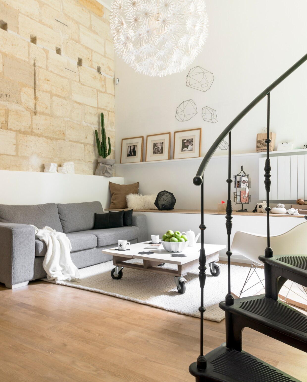 De bank is van Fly (www.fly.fr), het vloerkleed van AMPM, lamp van Ikea. De koffietafel is zelfgemaakt. De geometrische objecten zijn van Habitat, de bekers van Bloomingville, de papieren plantenzak is van Uashmama (via Moes &amp; Griet). Schaal en theepot gekocht in Bordeaux, kaartenrekje cadeau. vtwonen 03-2015 | fotografie Julien Fernandez / Amandinejules.com