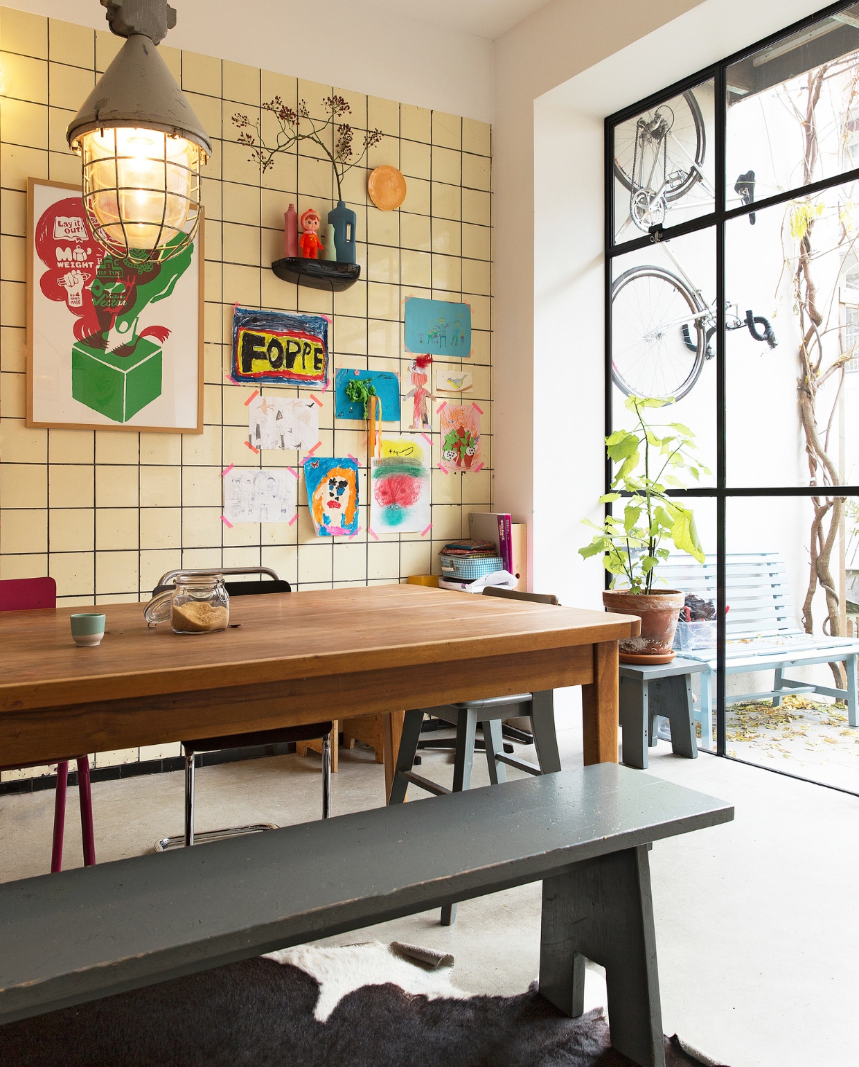 Eettafel gevonden in een oude loods, grijze bank zelf gemaakt. Stoelen van Piet Hein Eek, van Eames gevonden bij het grofvuil. Hanglamp van Neef Louis. Vazen van Een Bloemetje op Tafel. Bank en kleed Loods 5. Blauwe bank gemaakt door Frank de Bruijn van Supergoed. Groene lamp van Snowpuppe. Kastje en veel kaarten aan de muur van Spullen voor in je huis. Rood kunstwerk van Inez Odijk, schilderij met aap van Freya Wisman, werk in zwarte lijst van Piet Parra, bord met gezicht van Donna Wilson. Witte kruk achterin van Dulton Company, kruk op de voorgrond van Tolix, koeienhuid van Ikea. vtwonen special binnenkijken 121-2017 | styling Emmy van Dantzig | fotografie Jansje Klazinga