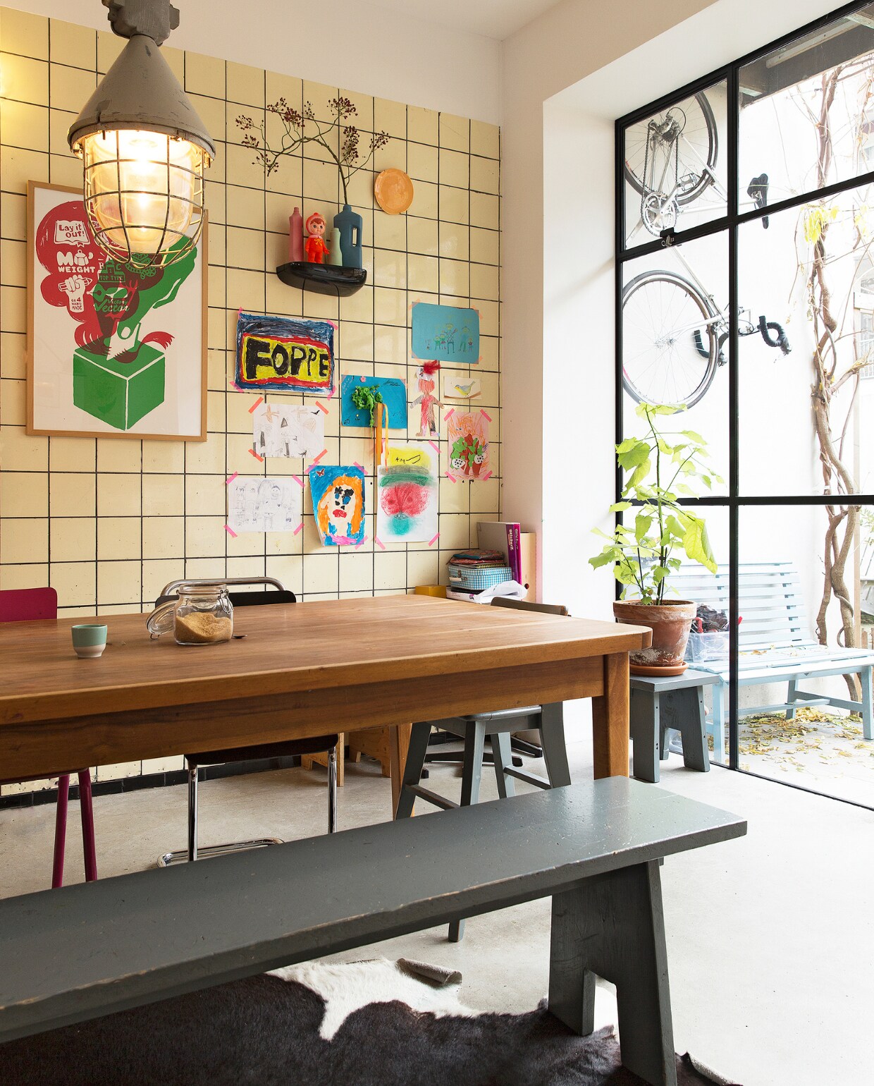 Eettafel gevonden in een oude loods, grijze bank zelf gemaakt. Stoelen van Piet Hein Eek, van Eames gevonden bij het grofvuil. Hanglamp van Neef Louis. Vazen van Een Bloemetje op Tafel. Bank en kleed Loods 5. Blauwe bank gemaakt door Frank de Bruijn van Supergoed. Groene lamp van Snowpuppe. Kastje en veel kaarten aan de muur van Spullen voor in je huis. Rood kunstwerk van Inez Odijk, schilderij met aap van Freya Wisman, werk in zwarte lijst van Piet Parra, bord met gezicht van Donna Wilson. Witte kruk achterin van Dulton Company, kruk op de voorgrond van Tolix, koeienhuid van Ikea. vtwonen special binnenkijken 121-2017 | styling Emmy van Dantzig | fotografie Jansje Klazinga