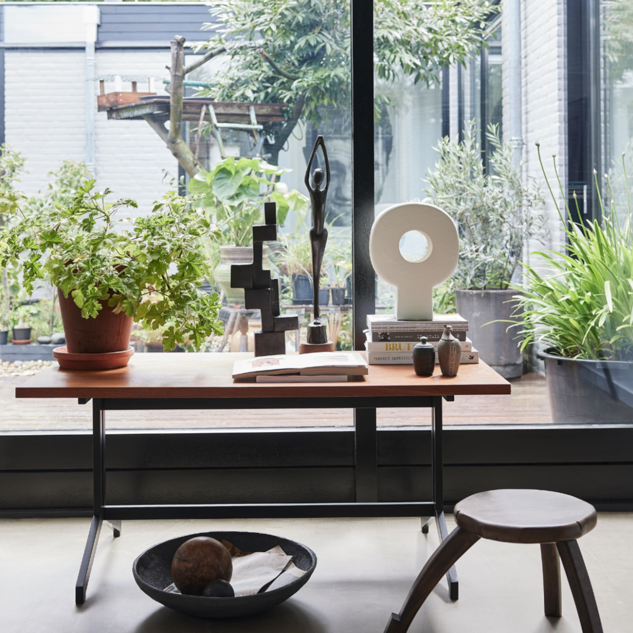 Botanisch interieur met een houten tafel vol kamerplanten en decoraties