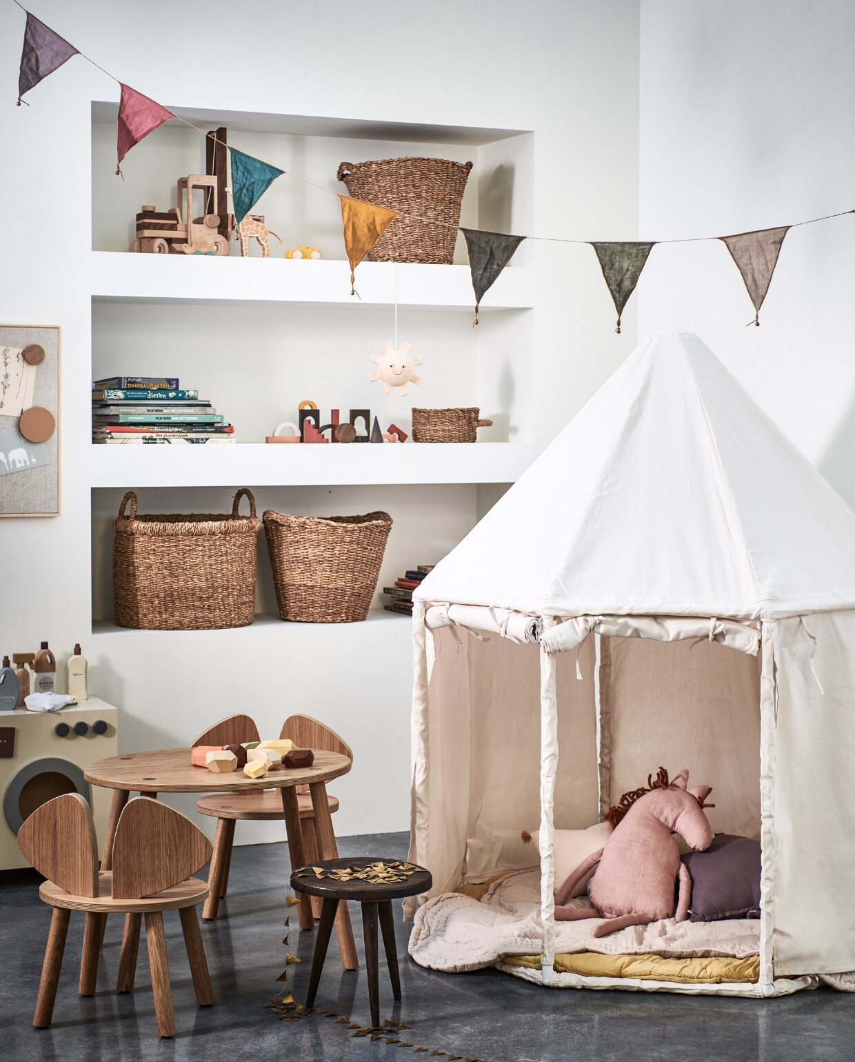 Canvas speelhuis van Kids Concept € 199,-, houten kindertafel Mouse van No Fred € 215,-, houten kinderstoel Mouse van No Fred € 185,-, magneet- en prikbord beige van Nofred € 135,-, magnetenset beige van Nofred € 40,- (vtwonen.nl). Houten wasmachine € 79,99, houten schoonmaakset € 29,99, muisvormige speelmat € 59,99, glow in the dark hanger zon € 17,99, opbergmanden met handvaten € 35,99, opbergmanden € 29,99, opbergmand met één handvat € 9,99 (zarahome.com). Knuffelkussen paard in Dusty Rose van Ferm Living € 55,- (storeofdaydreams.com). Stervormig kussen in kleur Dusty Lilac van Numero 74 € 19,-, roze kussen met kwastjes van Nobodinoz € 19,95, rond speelmatras Charlie in kleur Mellow Yellow van Numero 74 € 95,- (lidor.nl). Houten blokken Architectural Blocks van MinMin € 72,-, Balancing Stones pastel van MinMin € 46,- (gray-label.com). Houten vorkheftruck van Goki € 69,99 (lanoeka.com). Stoffen slinger multicolour van Numero 74 € 17,- (archive-store.nl). Overig privébezit. vtwonen 13-2021 | styling Kim van Rossenberg | fotografie Sjoerd Eickman