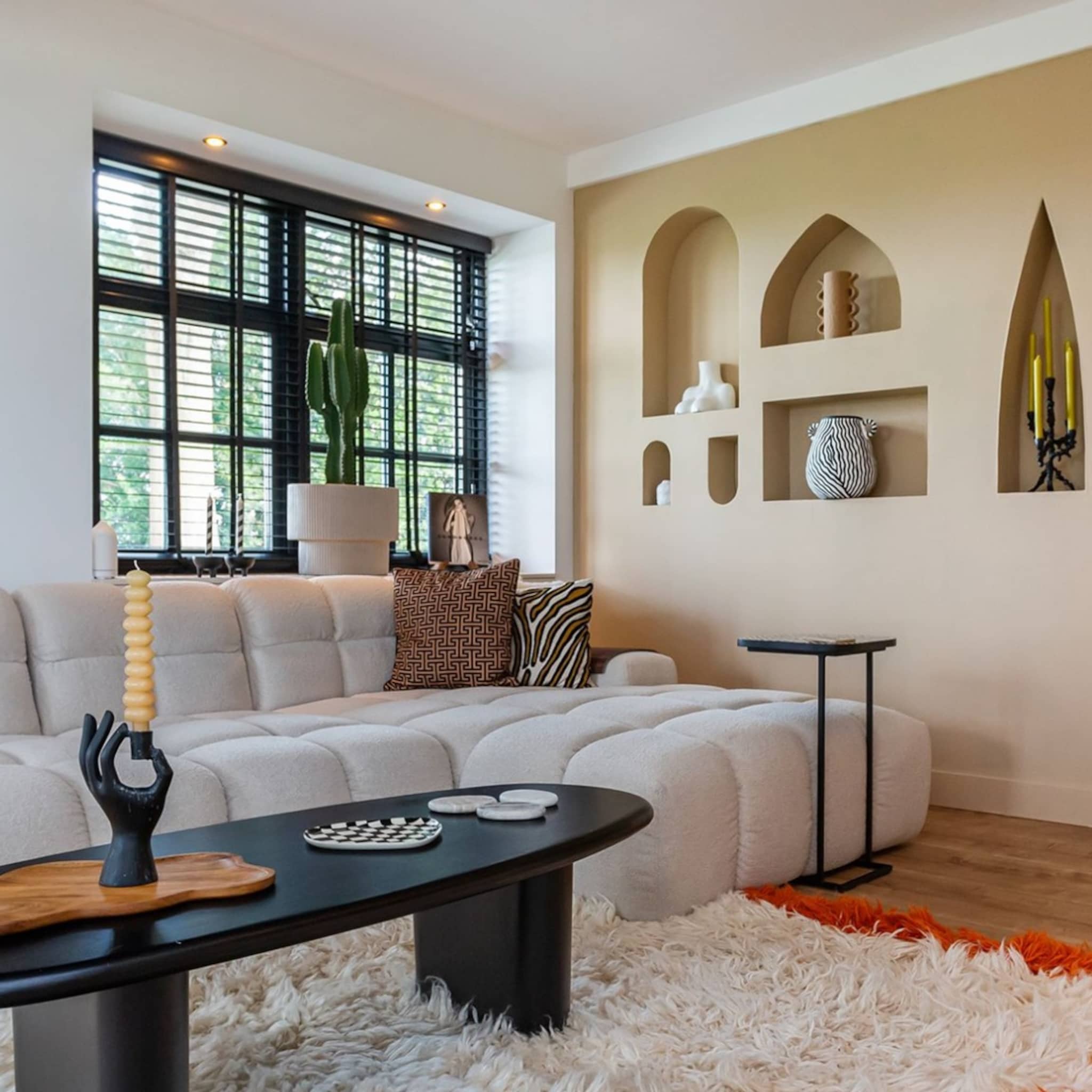 Moderne woonkamer met beige bank en een zwarte salontafel