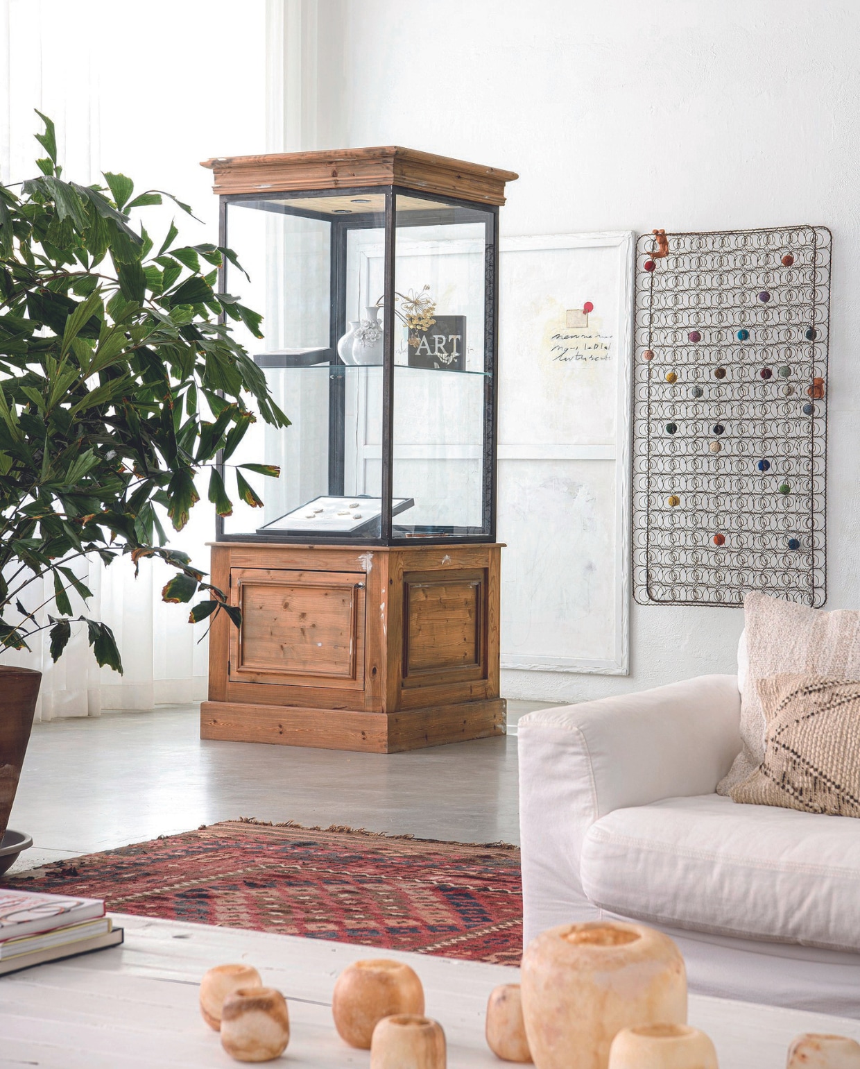 Vitrine vintage, witte vaasjes Polspotten, zwart kunstwerk Art en wit schilderij Eric de Bruijn, kunstwerk ernaast João Bruno Videira, bank Jan des Bouvrie voor Gelderland, kussens Liv Conceptstore, kelim vloerkleed vorige eigenaar, waxinelichtjeshouders Enter the loft. vtwonen 07-2024 | productie Inside Homepage | styling Anja Bas Backer | fotografie Louis Lemaire