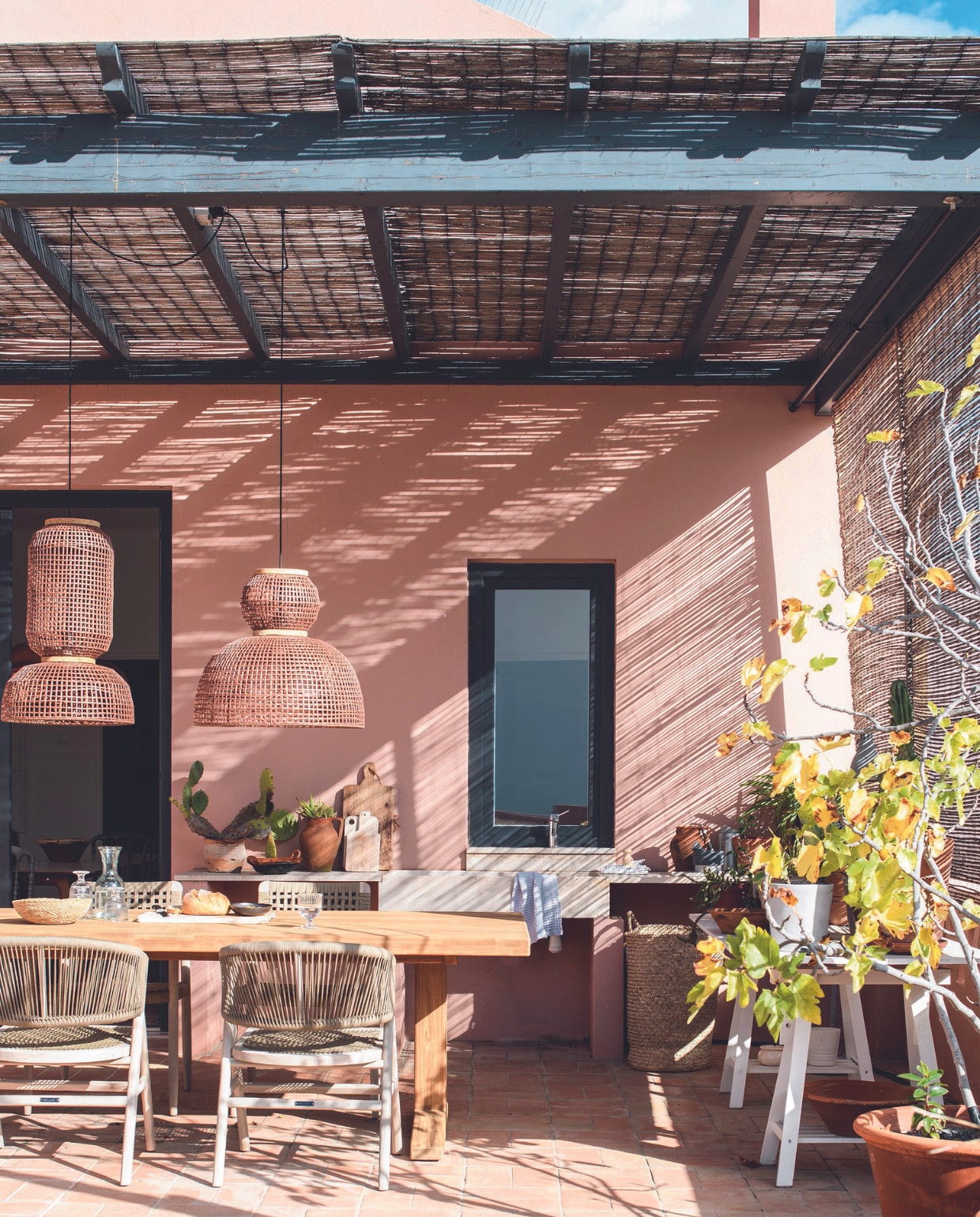 Tafel, stoelen en hanglampen Max &amp; Luuk, plantentafel Ikea, terracotta potten lokaal gekocht, buitenkeuken maatwerk vtwonen 07-2024 | productie Inside Homepage | styling Anja Bas Backer | fotografie Louis Lemaire