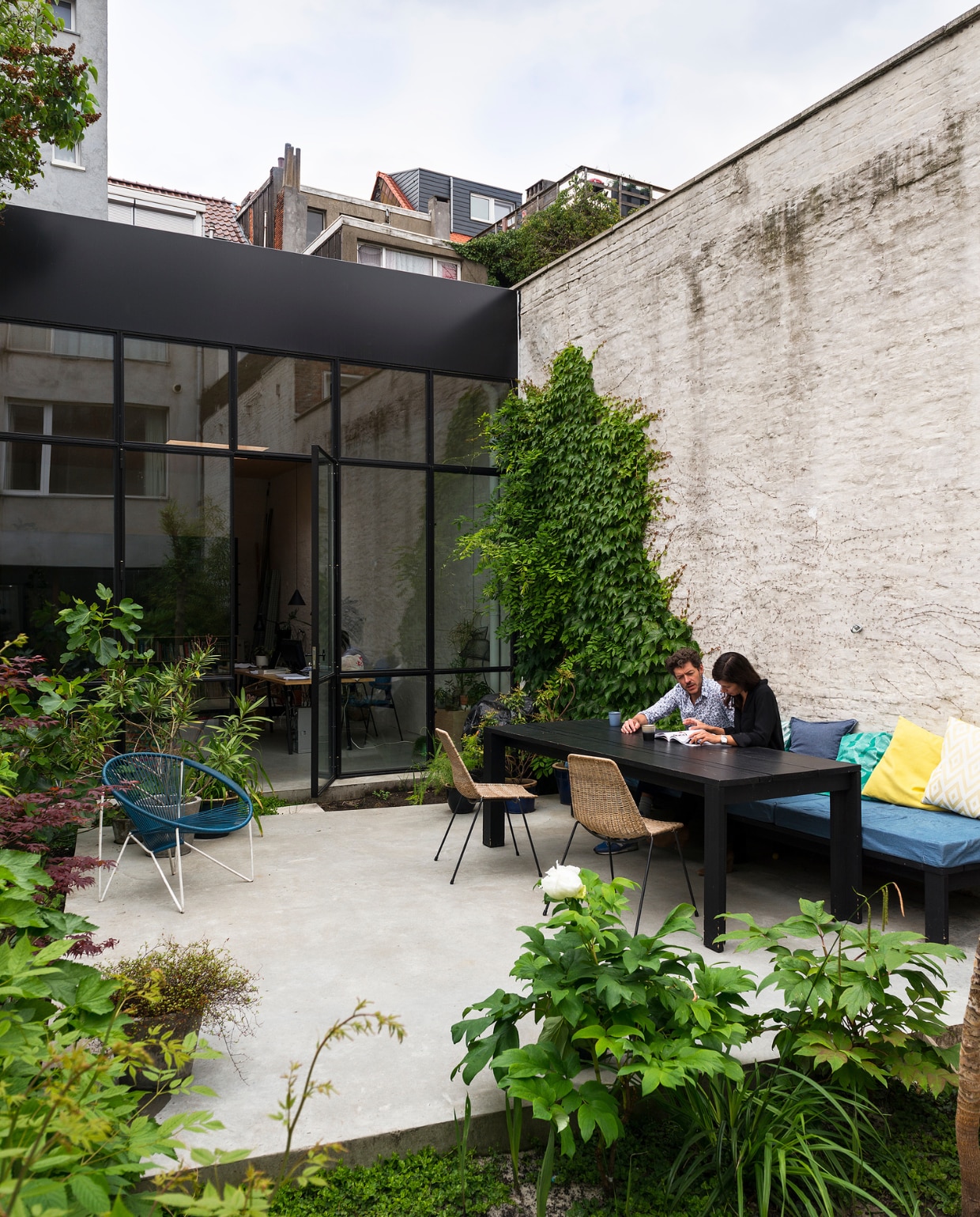 De tuin is ingericht met weelderige planten grote terrassen in beton.  vtwonen 10-2017 | Fotografie Stan Koolen