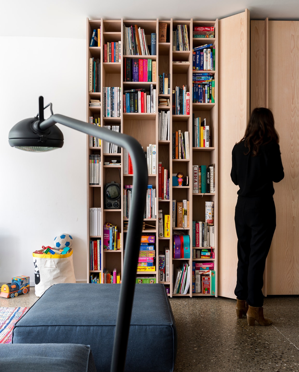 De open boekenkast ligt in het verlengde van het keukendeel en zet het lijnenspel van het geheel verder. Zo wordt ook de overgang aangegeven van eetruimte naar zitkamer. vtwonen 10-2017 | Fotografie Stan Koolen