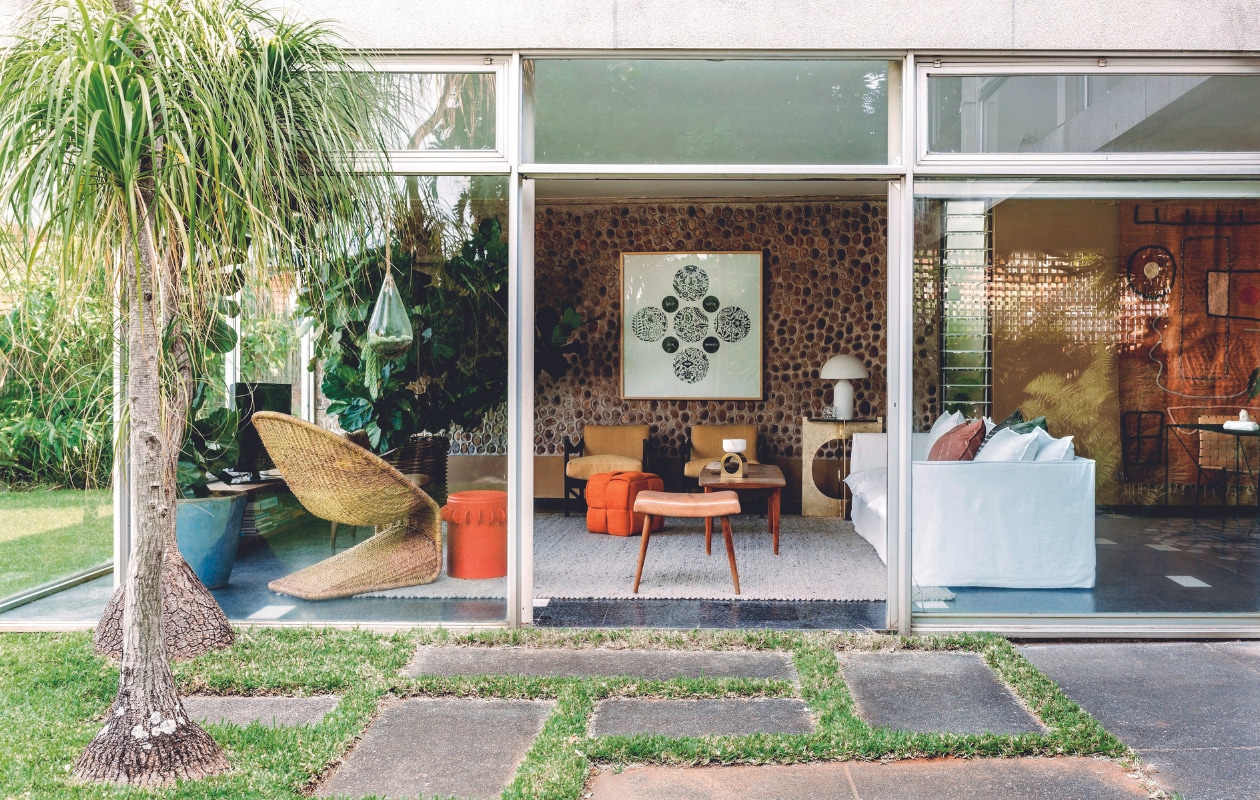 Vloer terrazzo, vloerkleed Hoffmann Rugs, bank maatwerk, schilderij Richard Hart, armfauteuils vintage, rieten fauteuil Singita, salontafel kringloop. Sidetable, poef en bronzen bijzettafel Tusker Trading. Voetenbank Kare, tafellamp Atollo van Oluce, eettafel Lisa Rorich, eetkamerstoelen Cécile &amp; Boyd, wandkleed Lrnce. vtwonen binnenkijkspecial 07-2024 | productie Living Inside | styling Luanne Toms | fotografie Lar Photography