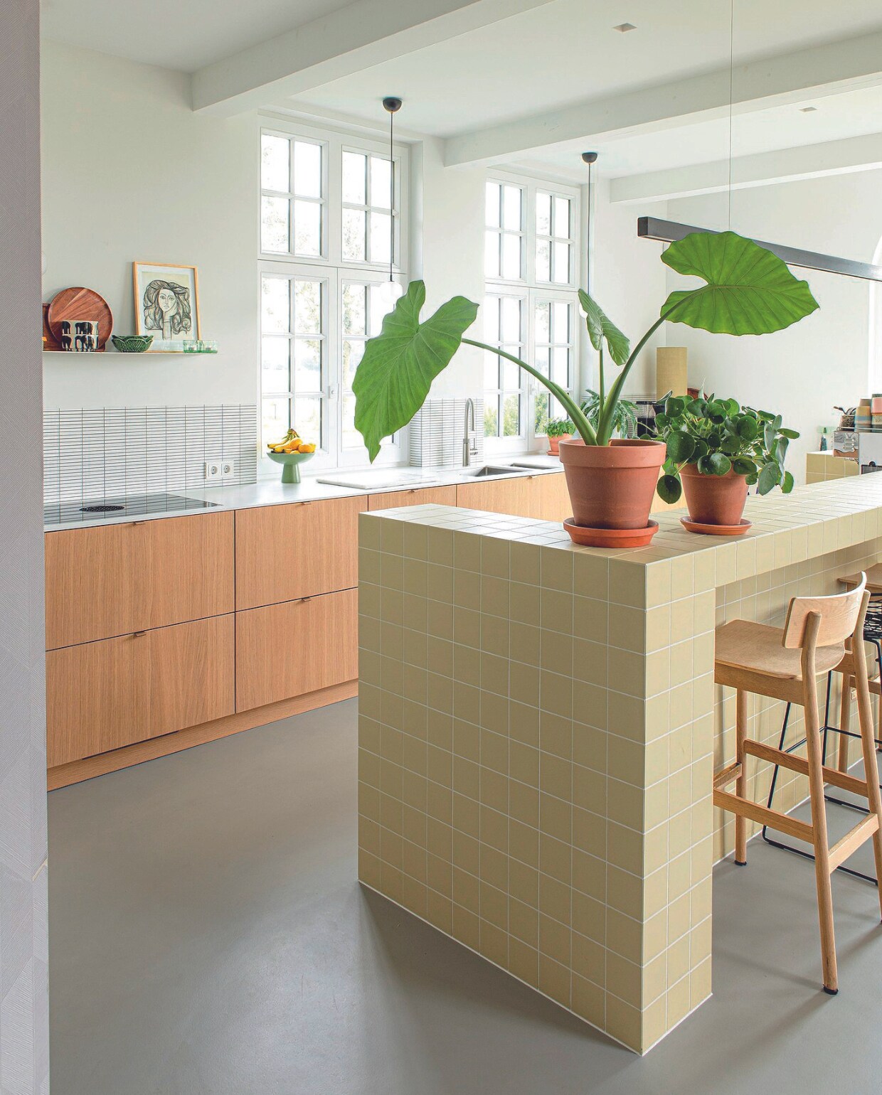 Spatwandtegels Estere Ceramica. Houten barkruk Woud. Plantenpotten Ikea, wandplank maatwerk, poster Picasso-museum Parijs, groene en zwart-wit schalen Arket. vtwonen 08-2024 | styling Jeske Weel | fotografie Caroline Coehorst