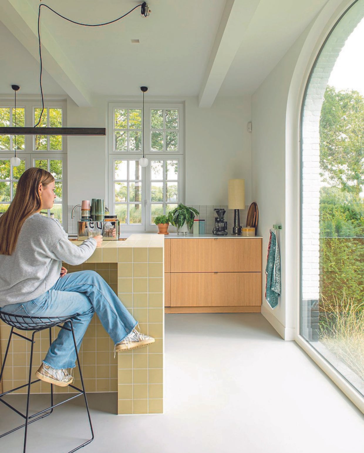 Keuken Van den Berg Keukens, keukenbar Winckelmans, barkruk Wire van Pastoe. Lampen Muuto, koffiemokken, tafellamp en snijplank HKliving, theedoeken Hay. vtwonen 08-2024 | styling Jeske Weel | fotografie Caroline Coehorst