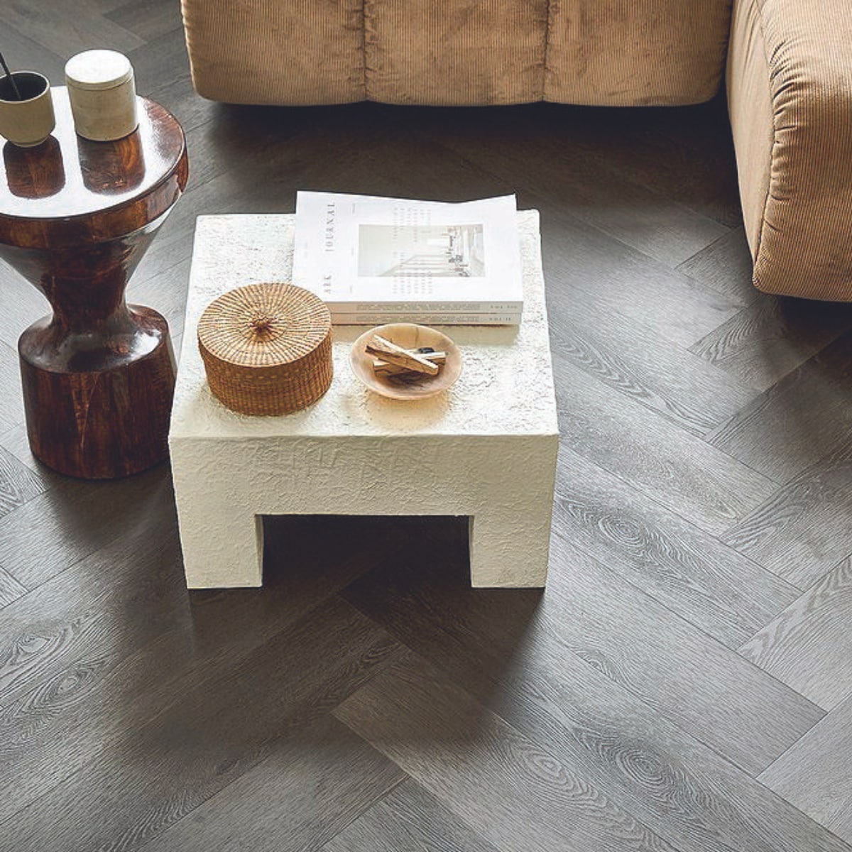 uitgelicht beeld : Pvc-vloer Herringbone in Charcoal, 76,5x15,3 cm, dryback per m² € 44,95 en click per m² € 57,95.M.m.v. hkliving.com (bijzettafel, elementenbank), urbannatureculture.com (salontafel). vtwonen 08-2024 | styling Marlies Does | fotografie Sjoerd Eickmans