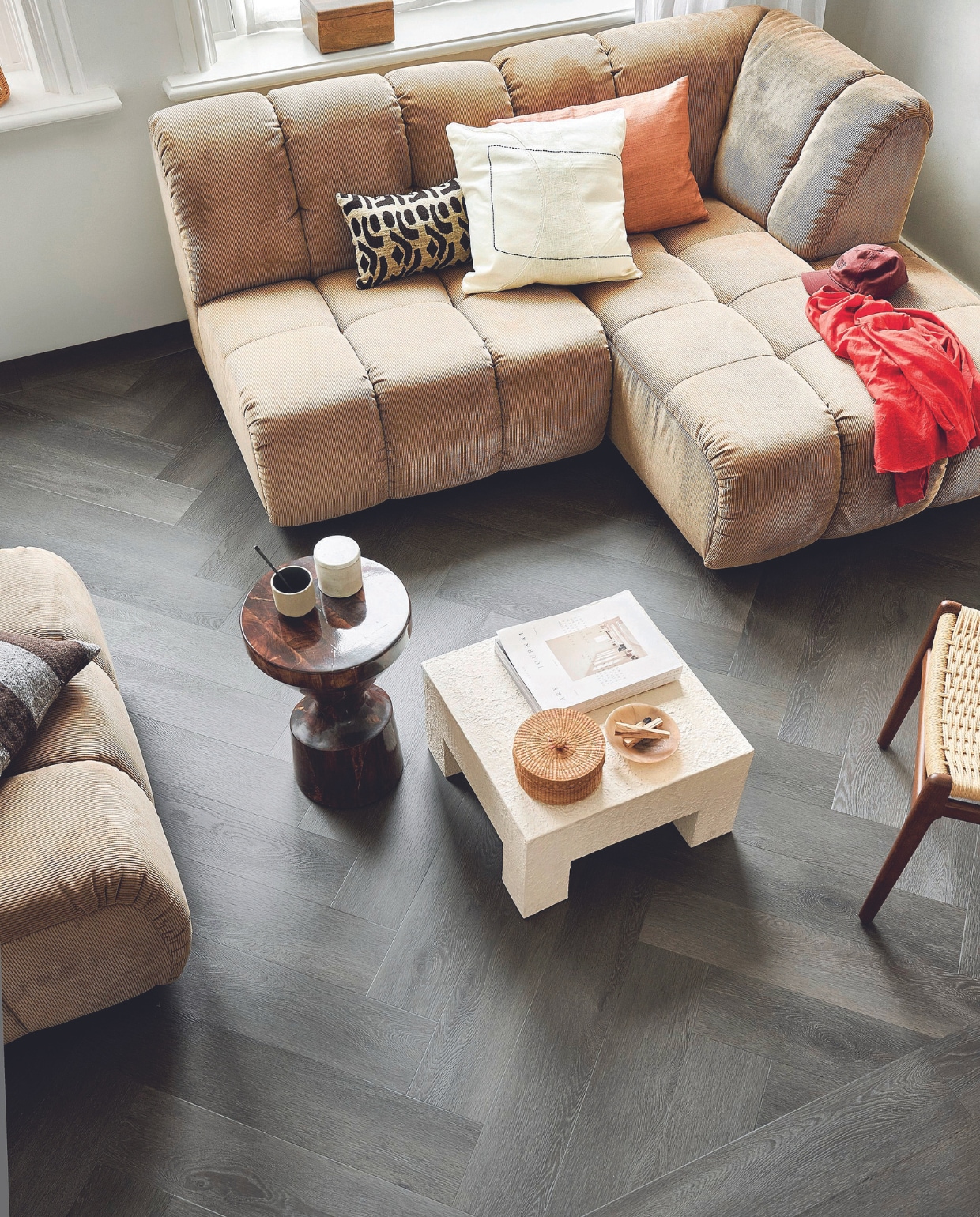 Pvc-vloer Herringbone in Charcoal, 76,5x15,3 cm, dryback per m² € 44,95 en click per m² € 57,95.M.m.v. hkliving.com (elementenbank, bijzettafel, bruin gestreept kussen, beige kussen met motief), urbannatureculture.com (salontafel, kistje, wit kussen met zwarte lijn, roze kussen), vtwonen.nl/shop (stoel Dutchbone) vtwonen 08-2024 | styling Marlies Does | fotografie Sjoerd Eickmans