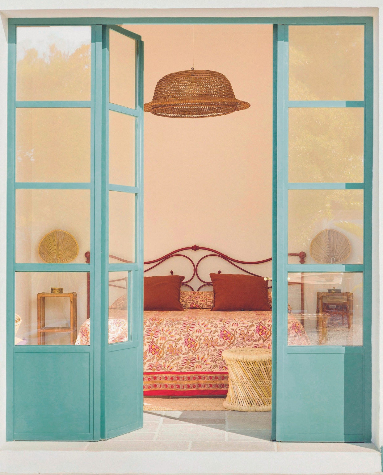 Deuren gemaakt door de plaatselijke smid. Bed tweedehands, kussens Ikea, sprei gemaakt van stof modebeurs. Overig vlooienmarkt. vtwonen binnenkijkspecial 07-2024 | productie Living Inside | styling Mirta Ottaviani | fotografie Mirko Morelli