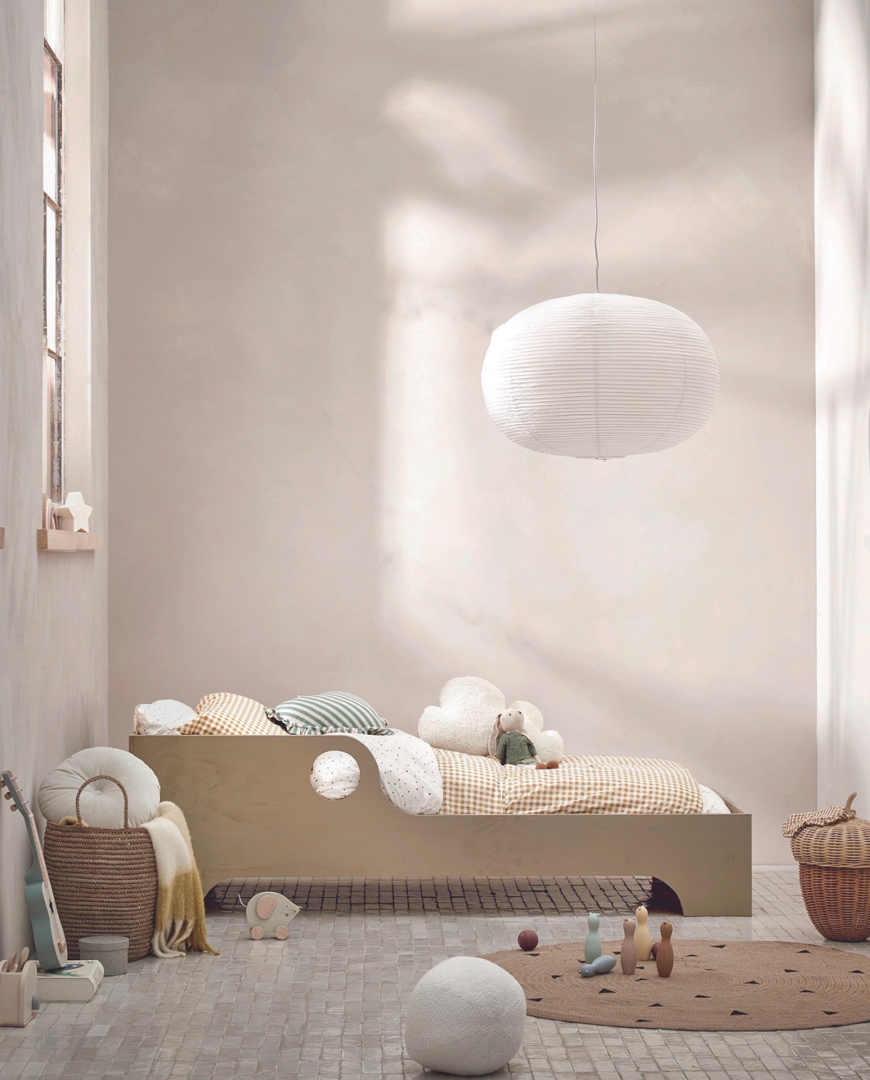 Juten vloerkleed van Ferm Living, 130 cm (Ø) € 69,-, papieren lampenkap Ellipse van Hay, 70x48 cm (Øxh) € 65,- rotan mand Eikel van Oyoy € 123,-, kussen in hartvorm € 39,99, oogmasker € 9,99, geel geblokt plaid, 130x180 cm € 69,99, wit velvet kussen € 29,99 (sissy-boy.com).Rieten mand € 59,99 speelgoedgitaar € 29,99,-, speelgoedbroodrooster € 29,99, bowlingspel € 22,99, speelgoedmuis op wielen € 12,99, houten regenboog € 22,99, stervormige nachtlamp € 15,99, stoffen knuffel haas € 22,99 (zarahome.com). Wit bolvormig kussen € 29,99, geel geruit dekbedovertrek, 140x200 cm € 24,99, dekbedovertrek met stippen, 140x200 cm € 24,99, opbergdoos € 9,99 (hm.com). vtwonen 08-2024 | styling Myla Griese | fotografie Louis Lemaire
