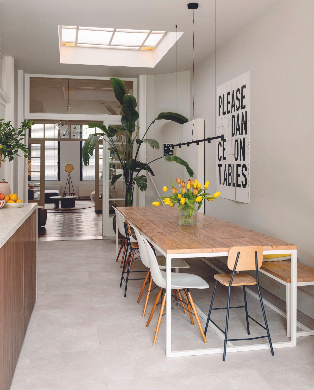 Eettafel en bank Pure Wood Design. Kinderstoelen Søstrene Grene, witte stoelen Vitra, Ixxi-kunstwerk My Deer Art Shop, lamp Trace Chandelier van Wever & Ducré, fruitschaal Sissy-Boy, lage fruitschaal Sara Delesie Keramiek, vloer Triana 46210 van Moduleo. vtwonen 08-2024 | styling Ilona Jongepier | fotografie Dana van Leeuwen