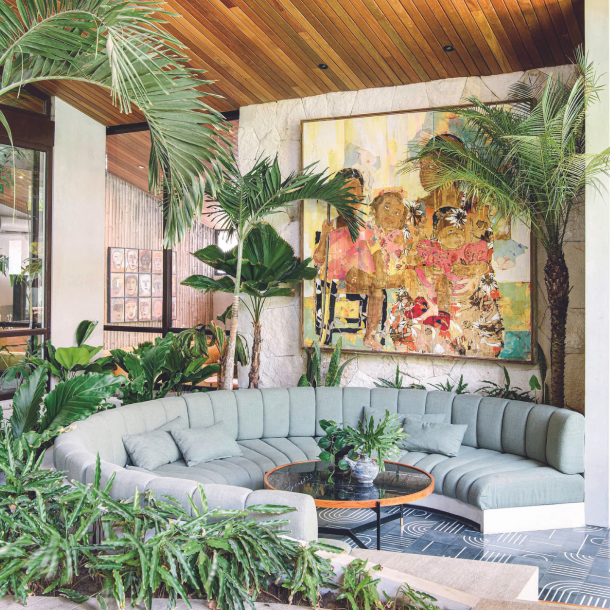 Botanische woonkamer met een ronde bank en grote kamerplanten